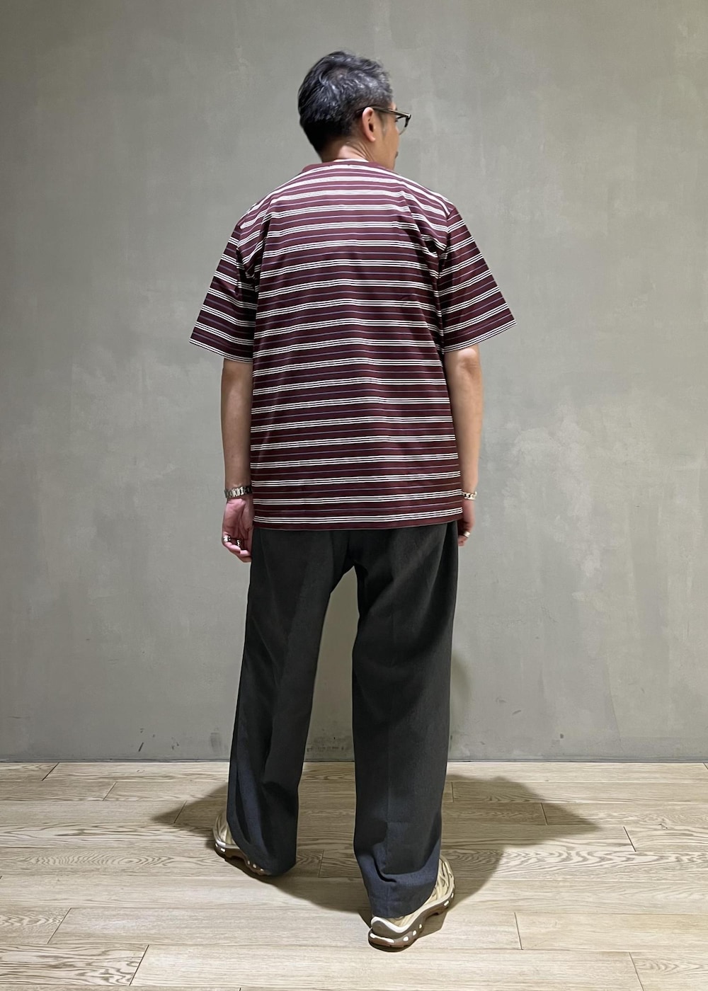 グレー系のスラックス、レッド系のTシャツ/カットソーを着用したメンズの春コーディネートの3枚目の写真