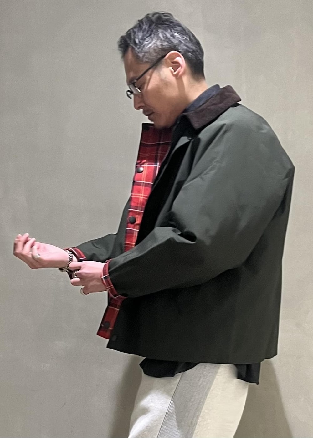 グリーン系のブルゾン、グレー系のその他パンツ、グレー系のカーディガン/ボレロを着用したメンズの冬コーディネートの5枚目の写真