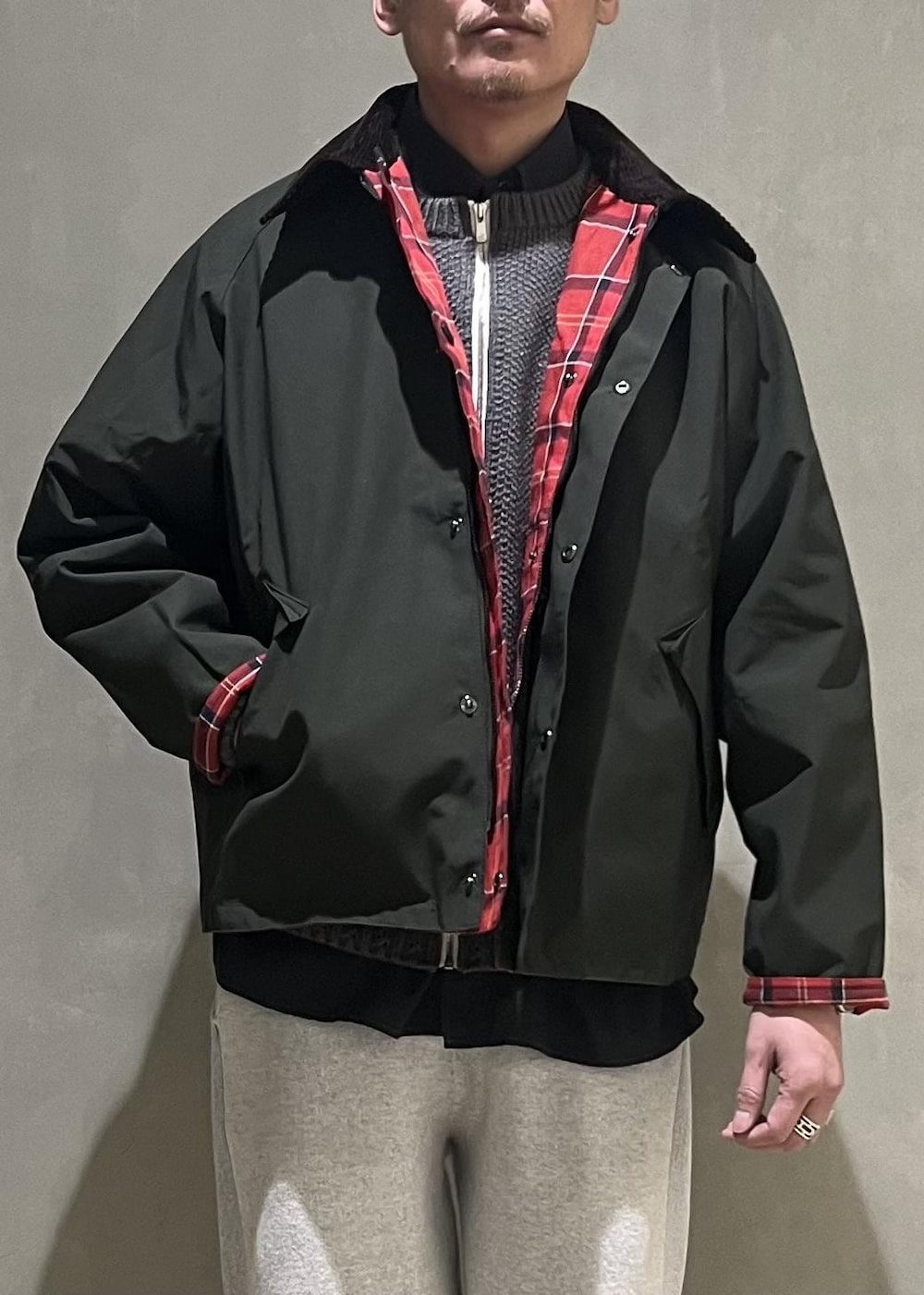 グリーン系のブルゾン、グレー系のその他パンツ、グレー系のカーディガン/ボレロを着用したメンズの冬コーディネートの4枚目の写真