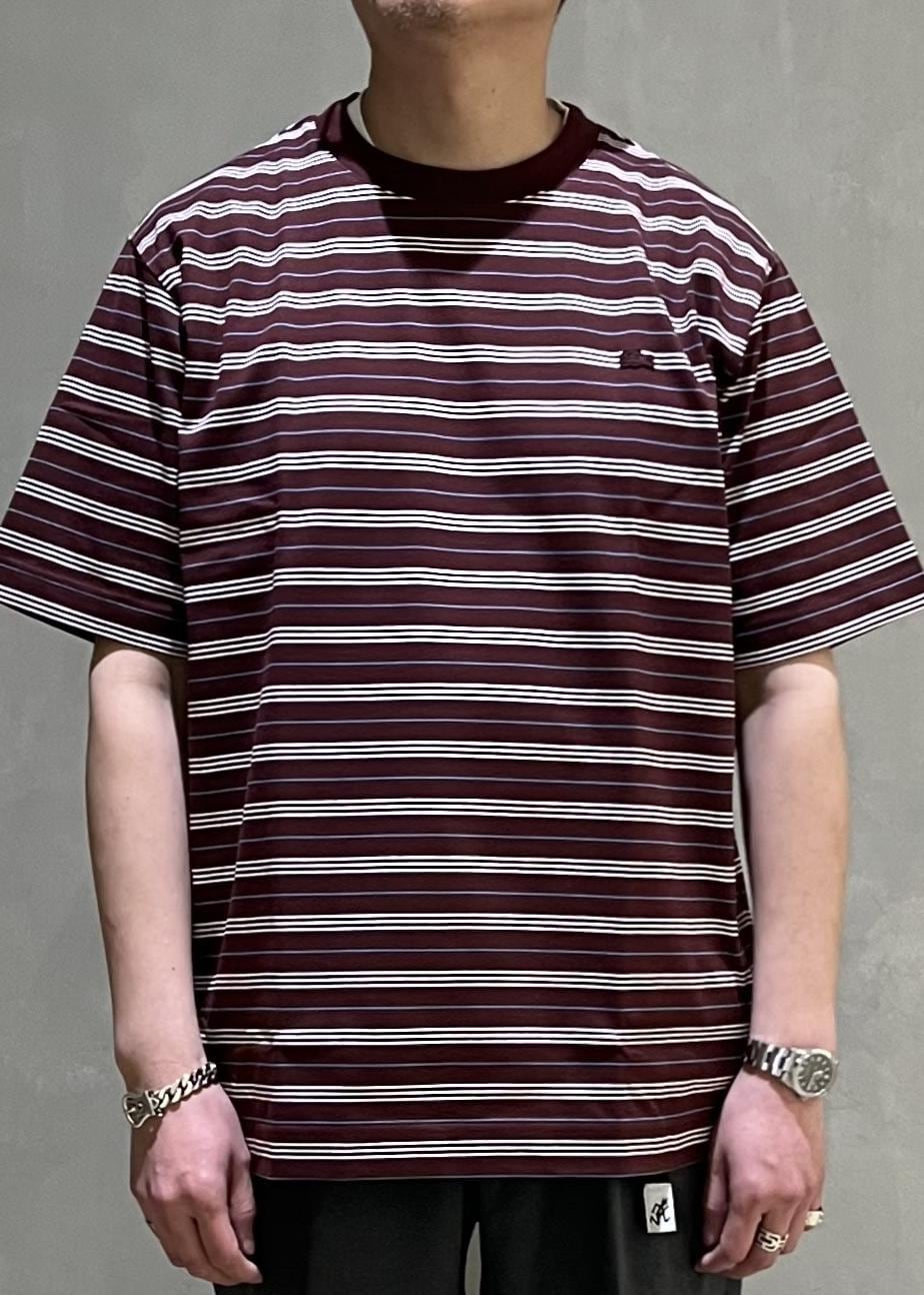 グレー系のスラックス、レッド系のTシャツ/カットソーを着用したメンズの春コーディネートの4枚目の写真