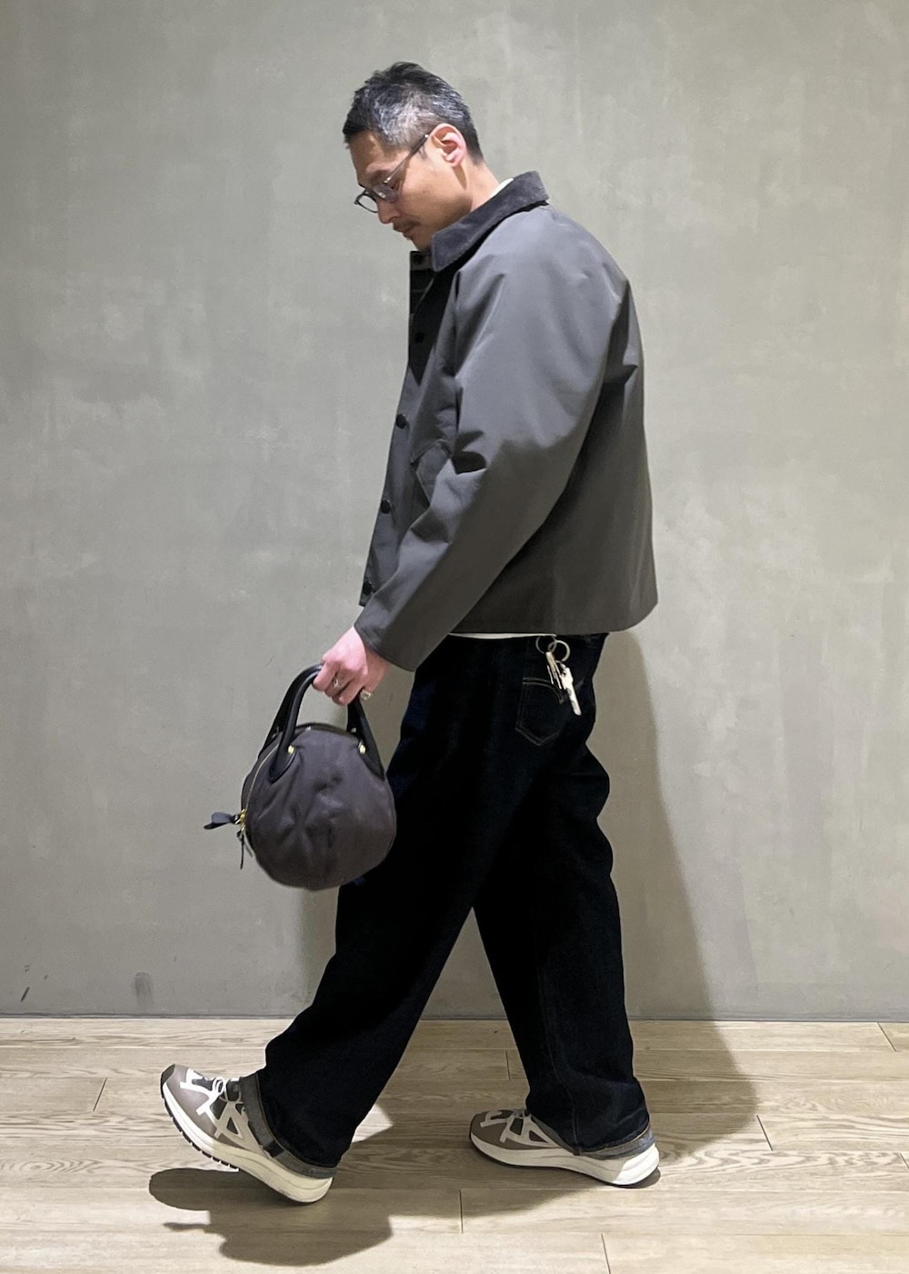 ブルー系のデニムパンツ、グレー系のブルゾン、ベージュ系のニット/セーターを着用したメンズの冬コーディネートの2枚目の写真