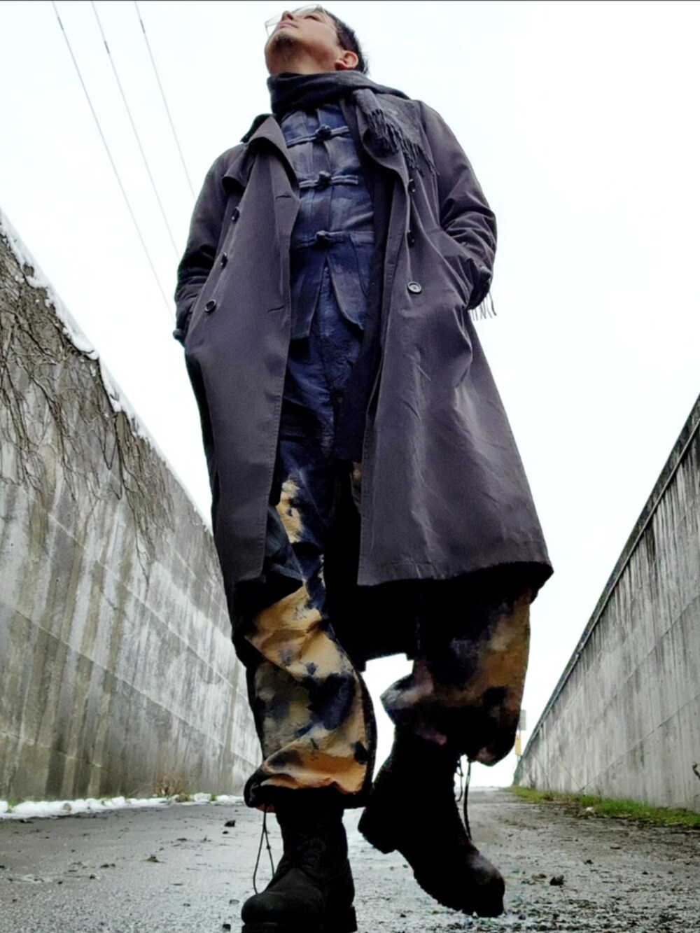 ブラック系のブーツ、その他のカーゴパンツ、グレー系のトレンチコートを着用したメンズの春コーディネートの2枚目の写真