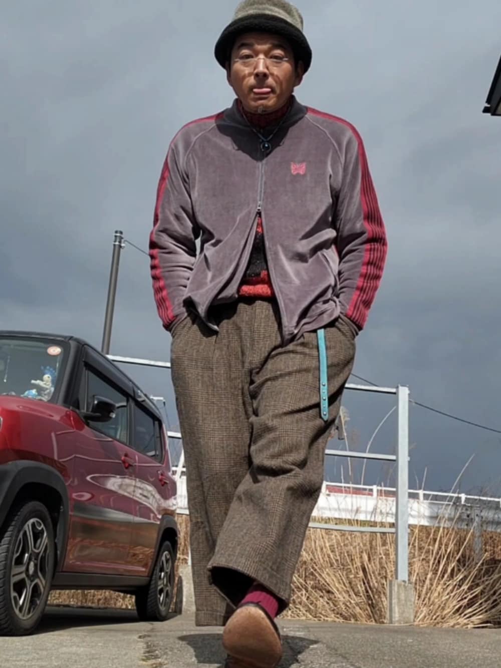 グレー系のスラックス、グレー系のジャージ、ブラック系のドレスシューズを着用したメンズの冬コーディネートの2枚目の写真