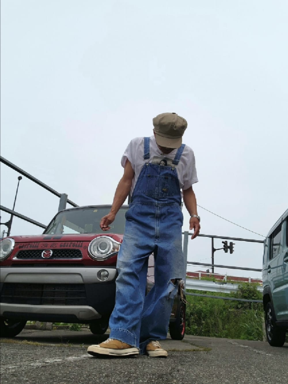 ブルー系のサロペット/オーバーオール、ベージュ系のスニーカー、ホワイト系のTシャツ/カットソーを着用したメンズの春コーディネートの4枚目の写真