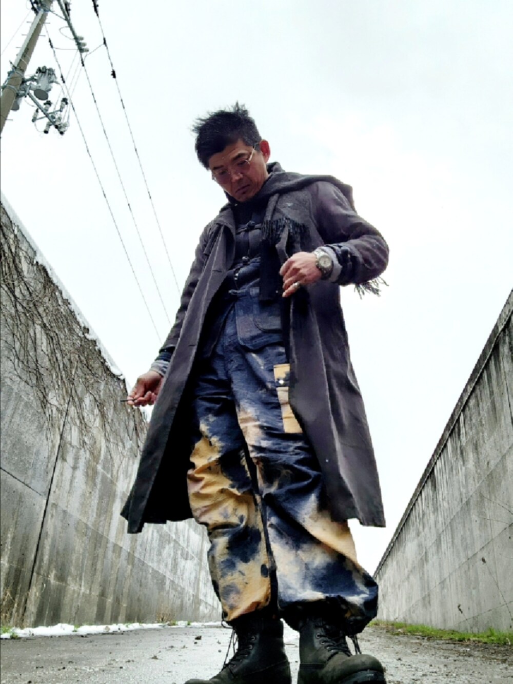 ブラック系のブーツ、その他のカーゴパンツ、グレー系のトレンチコートを着用したメンズの春コーディネートの4枚目の写真