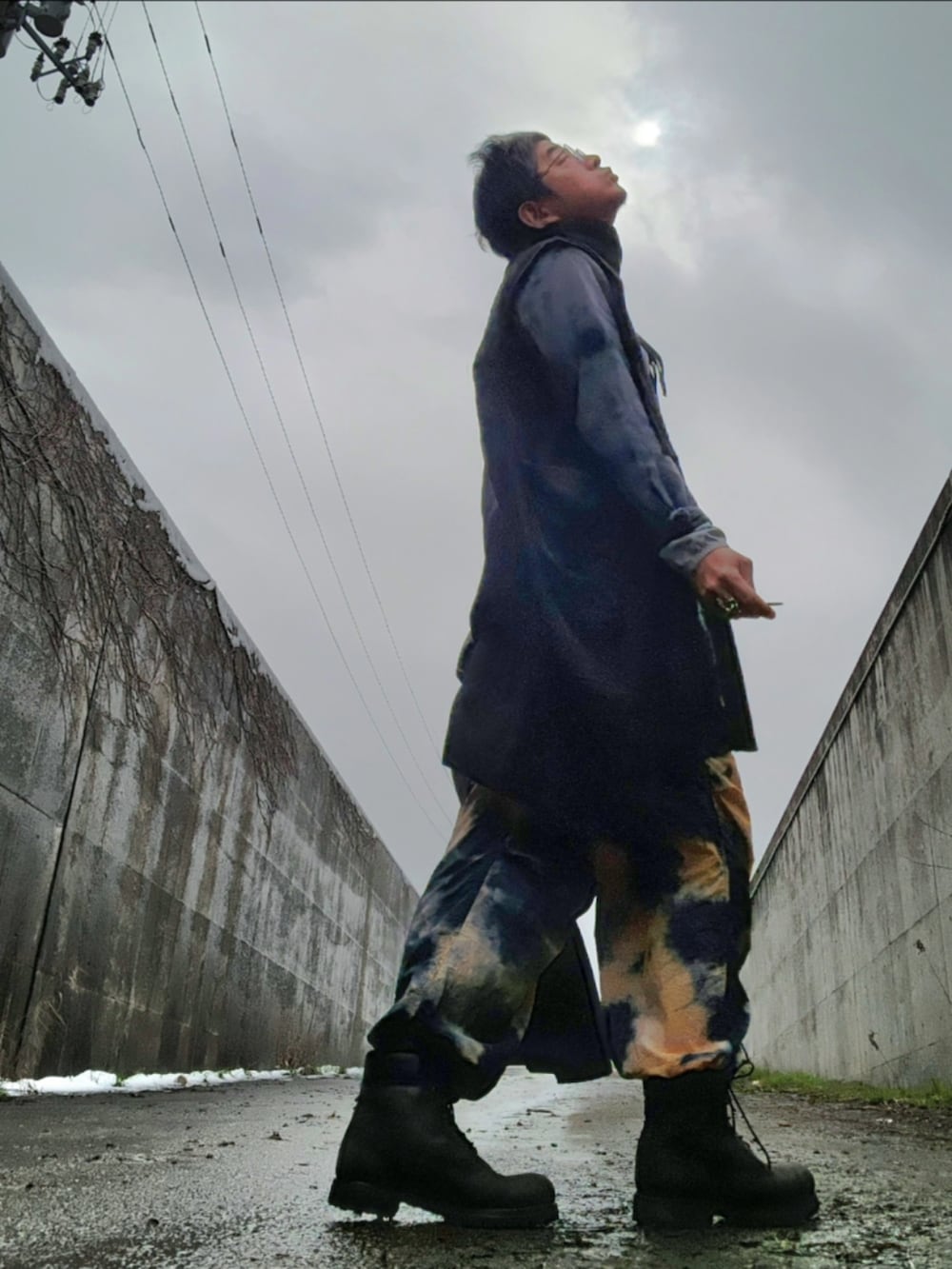 ブラック系のブーツ、その他のカーゴパンツ、グレー系のトレンチコートを着用したメンズの春コーディネートの3枚目の写真