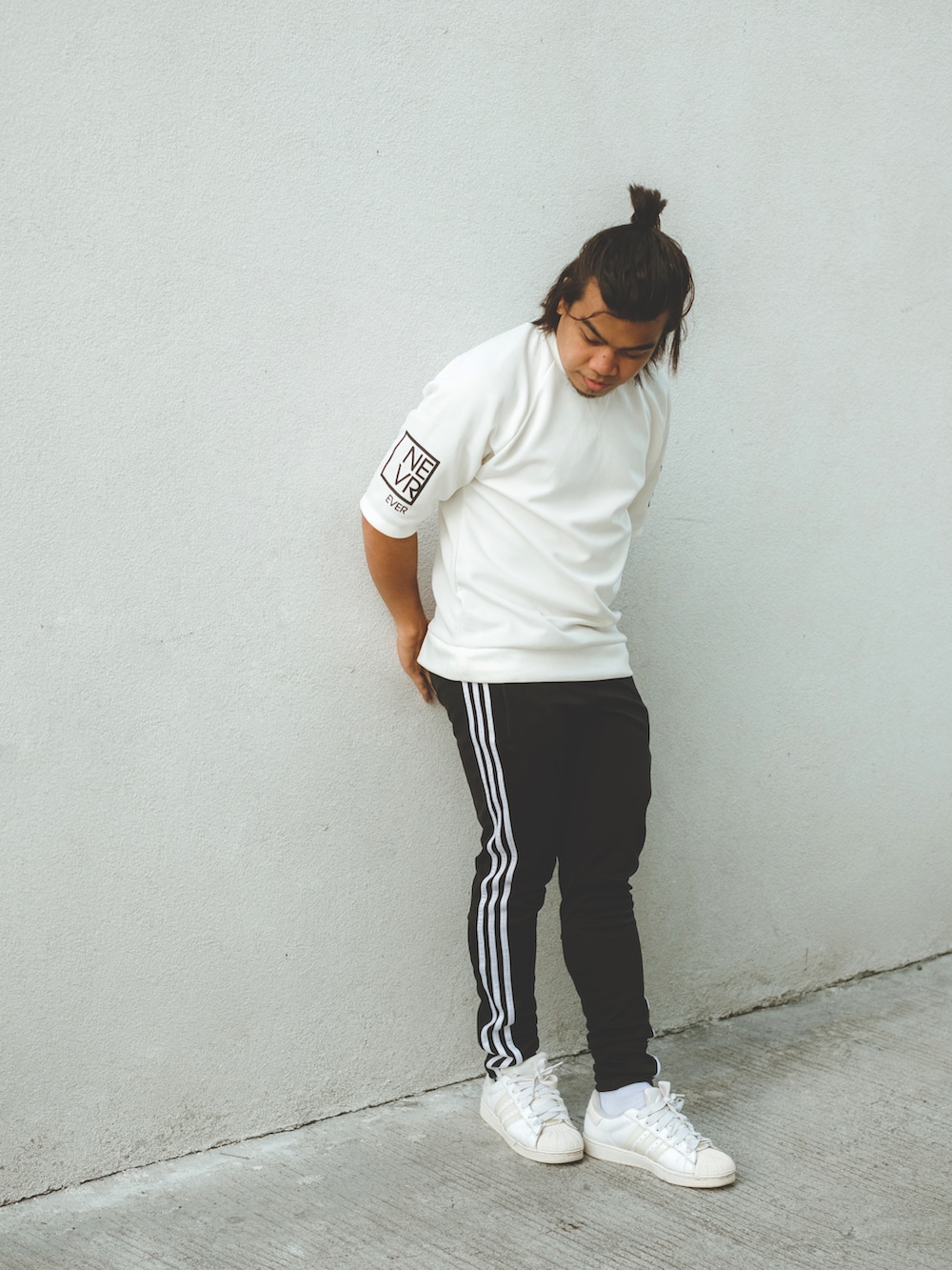 ブラック系のスウェットパンツ、ホワイト系のTシャツ/カットソー、ホワイト系のスニーカーを着用したメンズの夏コーディネートの3枚目の写真