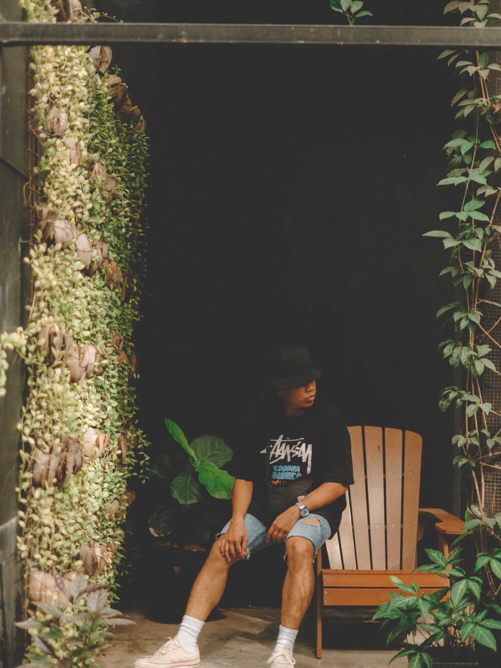 ブラック系のTシャツ/カットソー、ホワイト系のスニーカー、ブラック系のキャップを着用したメンズの夏コーディネートの2枚目の写真