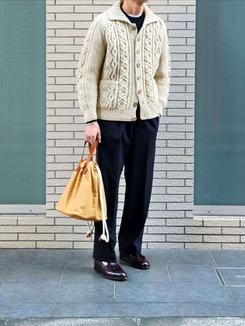 ベージュ系のその他アウター、ブラック系のニット/セーター、ブルー系のスラックスを着用したメンズの冬コーディネートの2枚目の写真