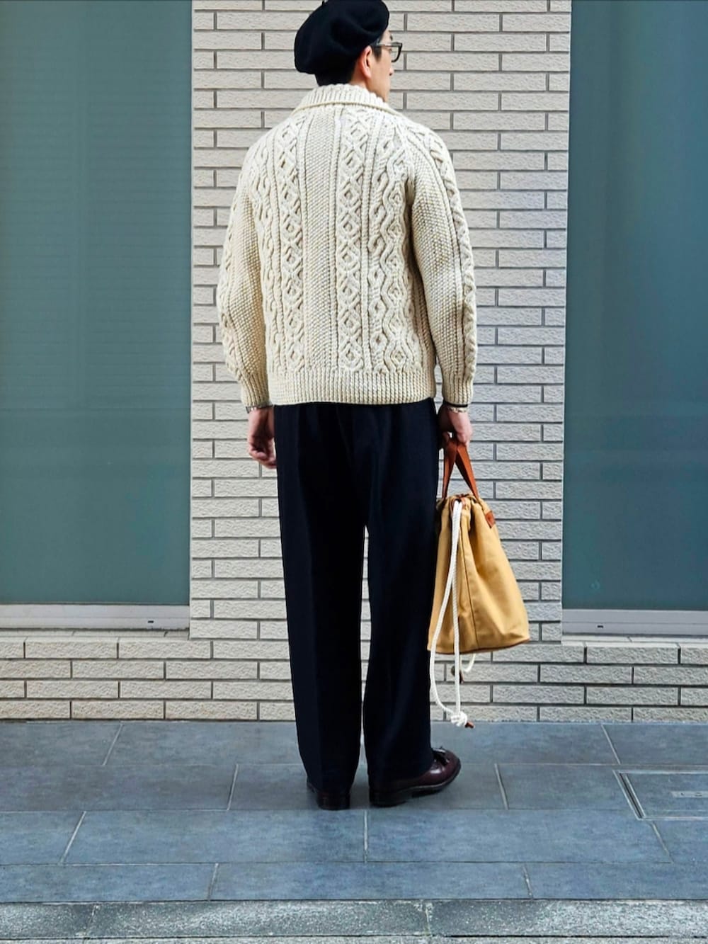 ベージュ系のその他アウター、ブラック系のニット/セーター、ブルー系のスラックスを着用したメンズの冬コーディネートの3枚目の写真