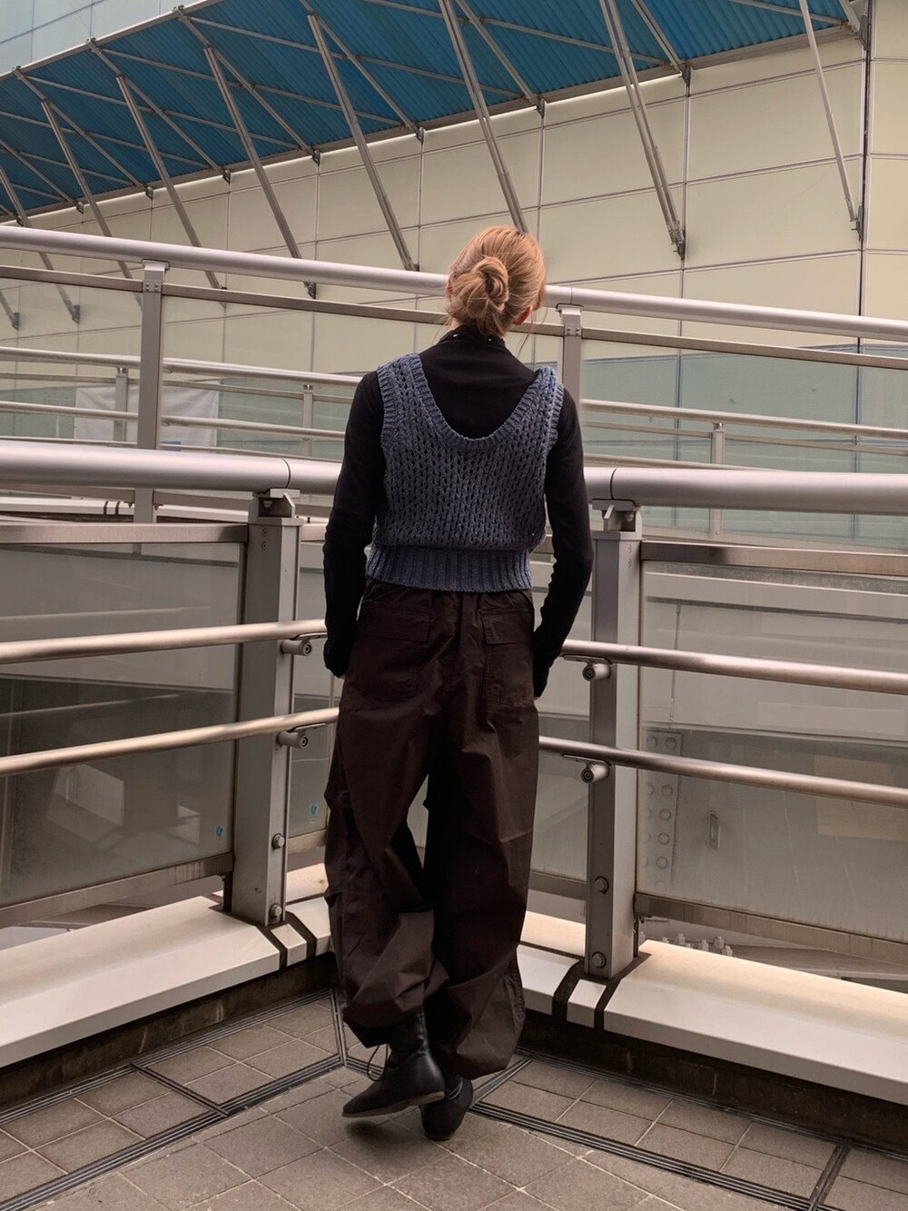 ブルー系のチェスターコート、ブラック系のブーツ、ブラック系のTシャツ/カットソーを着用したレディースの冬コーディネートの5枚目の写真