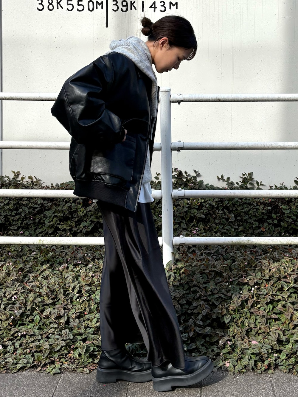 ホワイト系のTシャツ/カットソー、ブラック系のブルゾン、ブラック系のスカートを着用したレディースの冬コーディネートの2枚目の写真