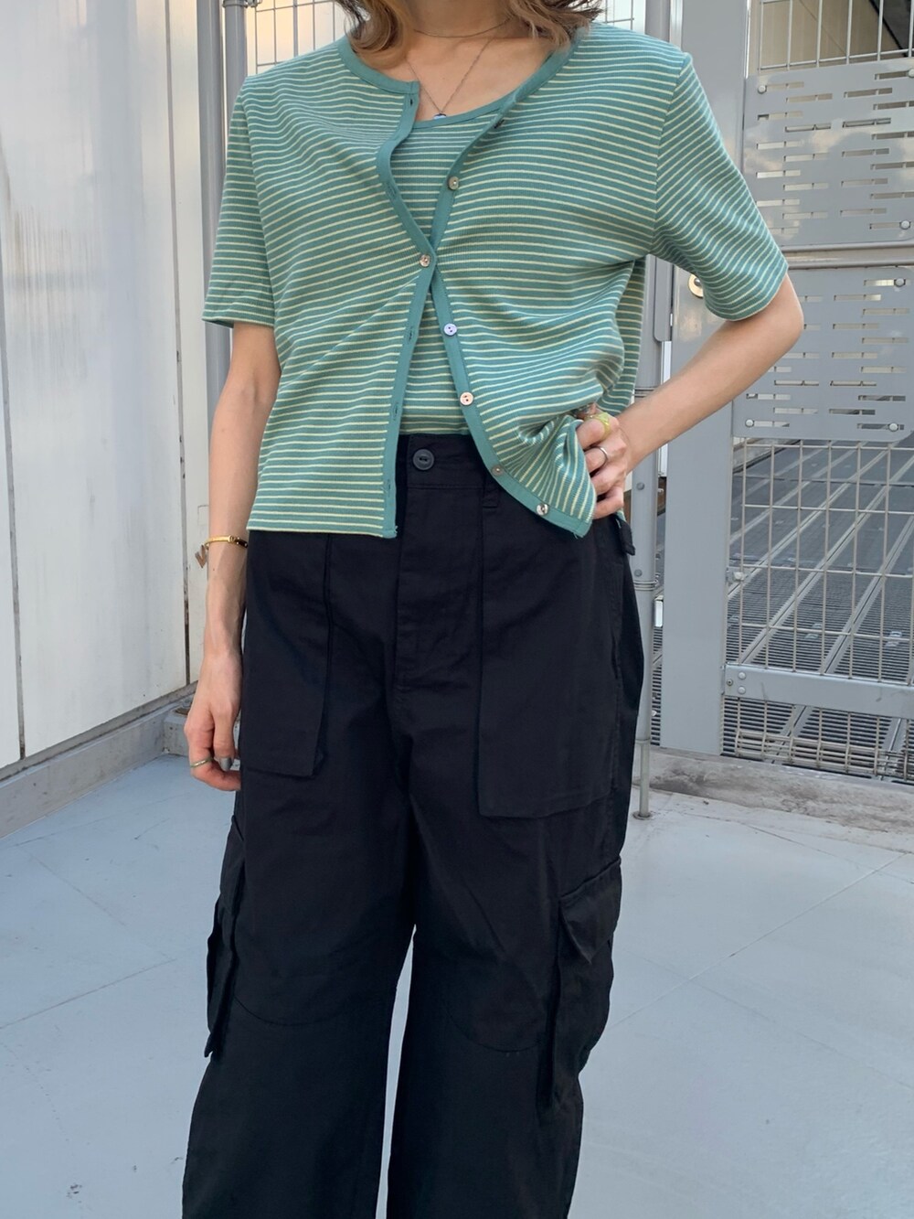 ブラック系のカーゴパンツ、イエロー系のキャミソール、シルバー系のパンプスを着用したレディースの夏コーディネートの2枚目の写真