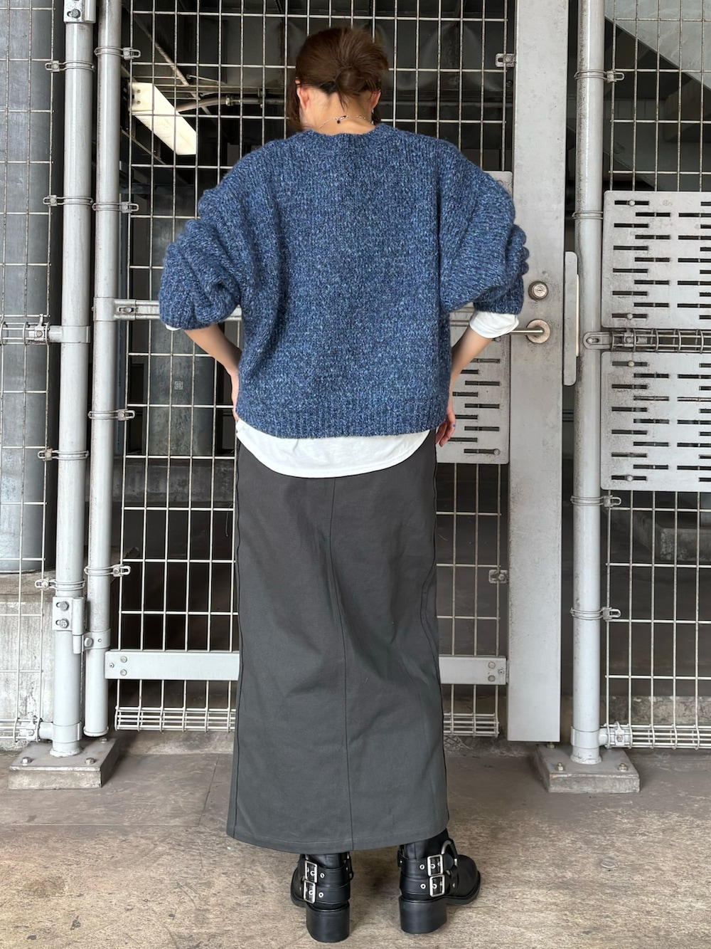 ブラック系のブーツ、ブルー系のニット/セーター、ホワイト系のTシャツ/カットソーを着用したレディースの秋コーディネートの3枚目の写真