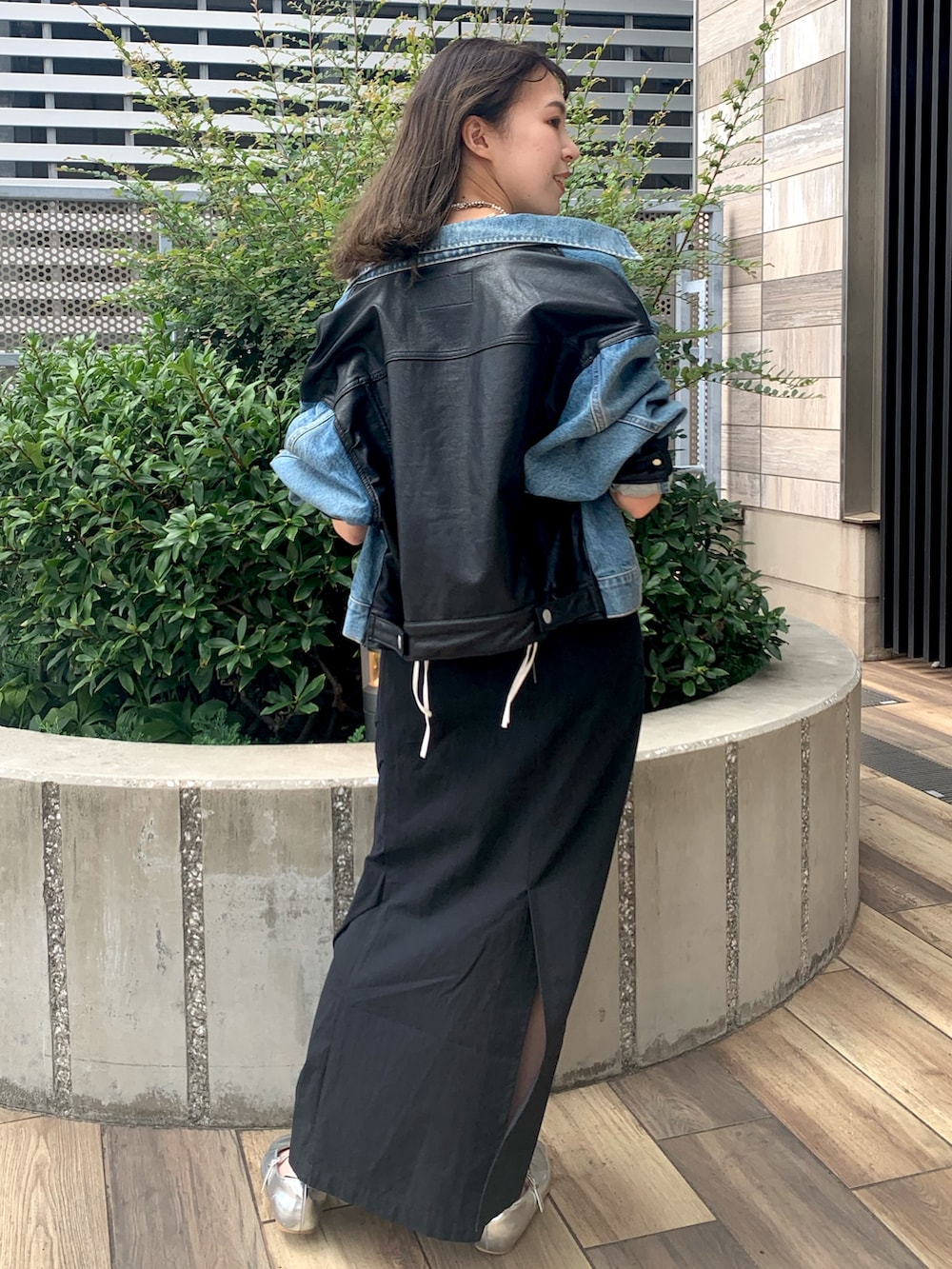 ブラック系のスカート、ブルー系のデニムジャケット、ホワイト系のTシャツ/カットソーを着用したレディースの秋コーディネートの3枚目の写真