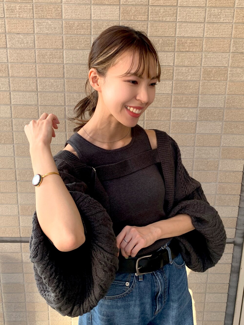 ブルー系のデニムパンツ、グレー系のカーディガン/ボレロ、ブラック系のパンプスを着用したレディースの秋コーディネートの5枚目の写真