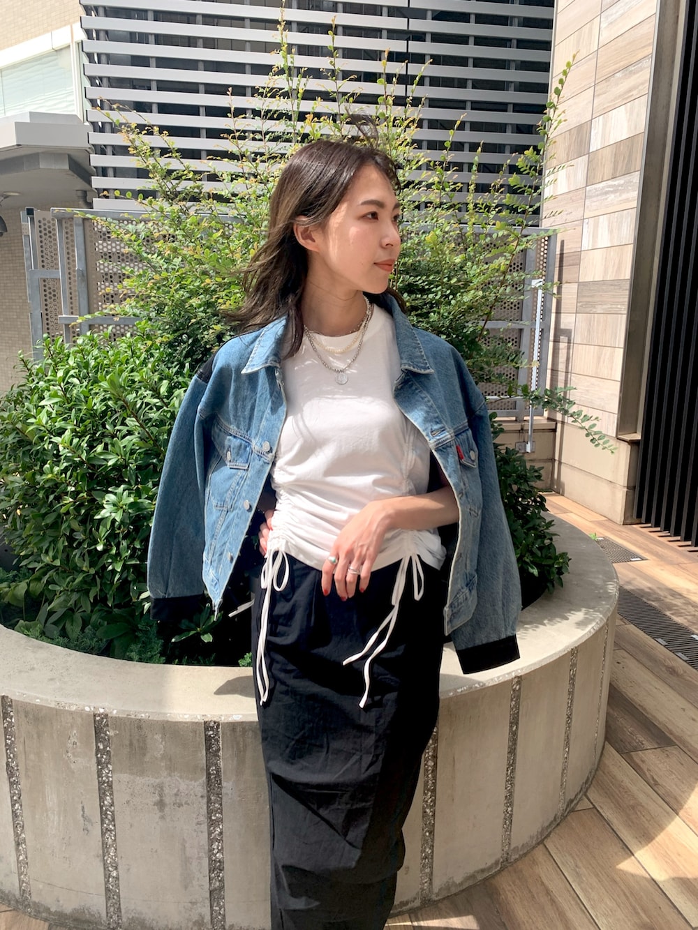 ブラック系のスカート、ブルー系のデニムジャケット、ホワイト系のTシャツ/カットソーを着用したレディースの秋コーディネートの4枚目の写真