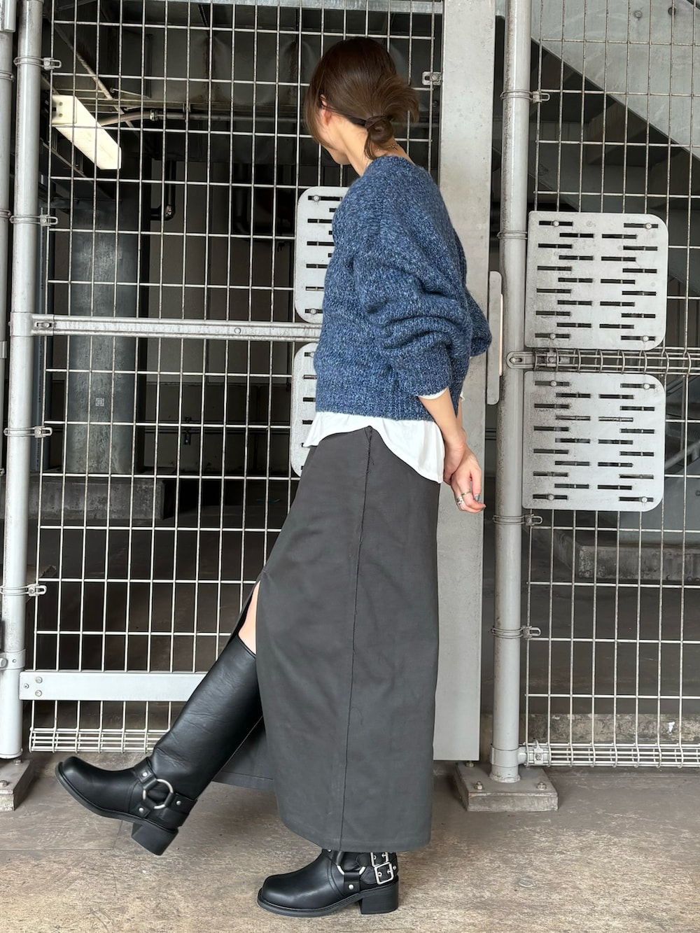 ブラック系のブーツ、ブルー系のニット/セーター、ホワイト系のTシャツ/カットソーを着用したレディースの秋コーディネートの2枚目の写真