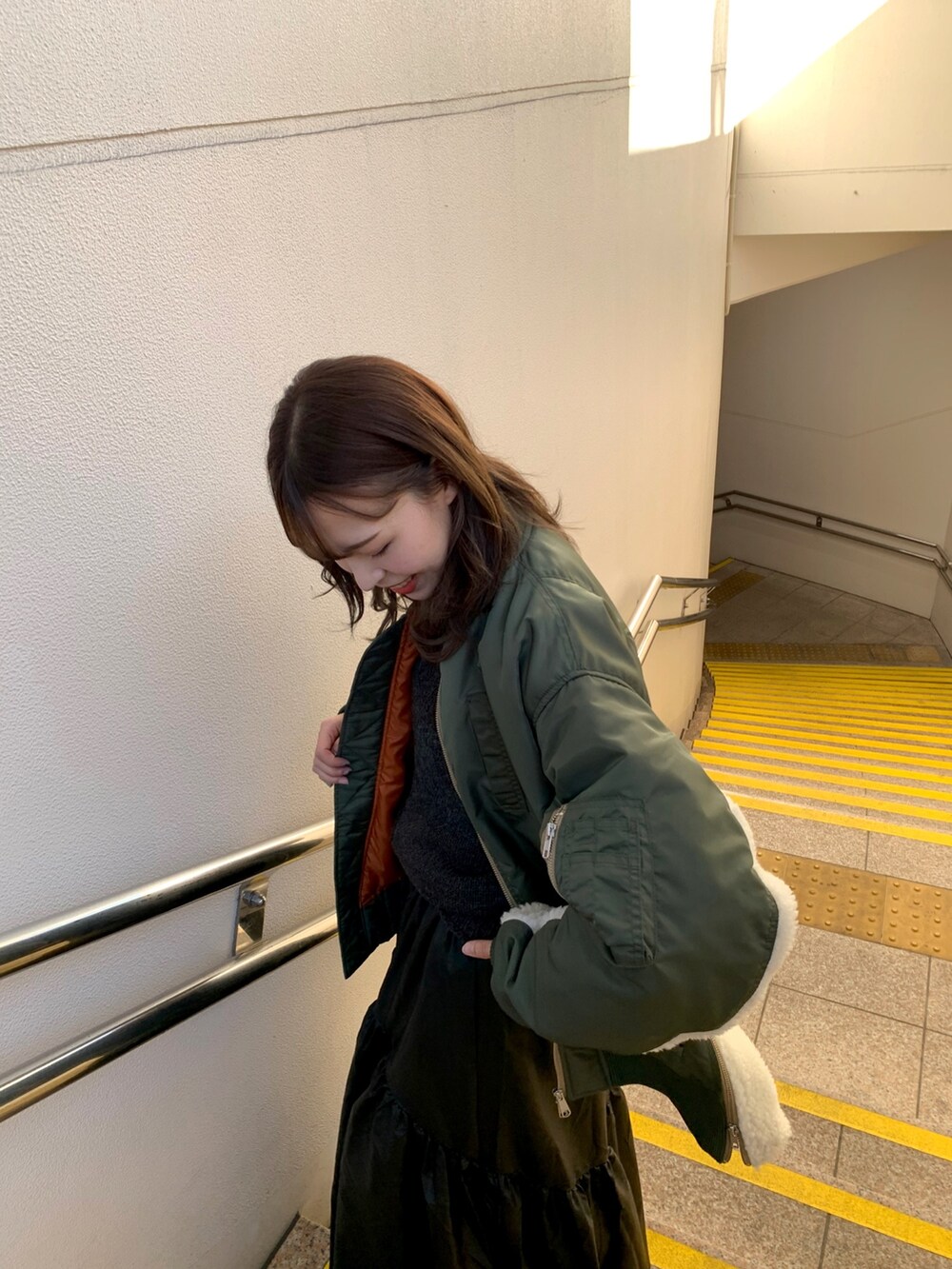 ブラック系のスカート、ブラック系のブーツ、グレー系のニット/セーターを着用したレディースの冬コーディネートの4枚目の写真