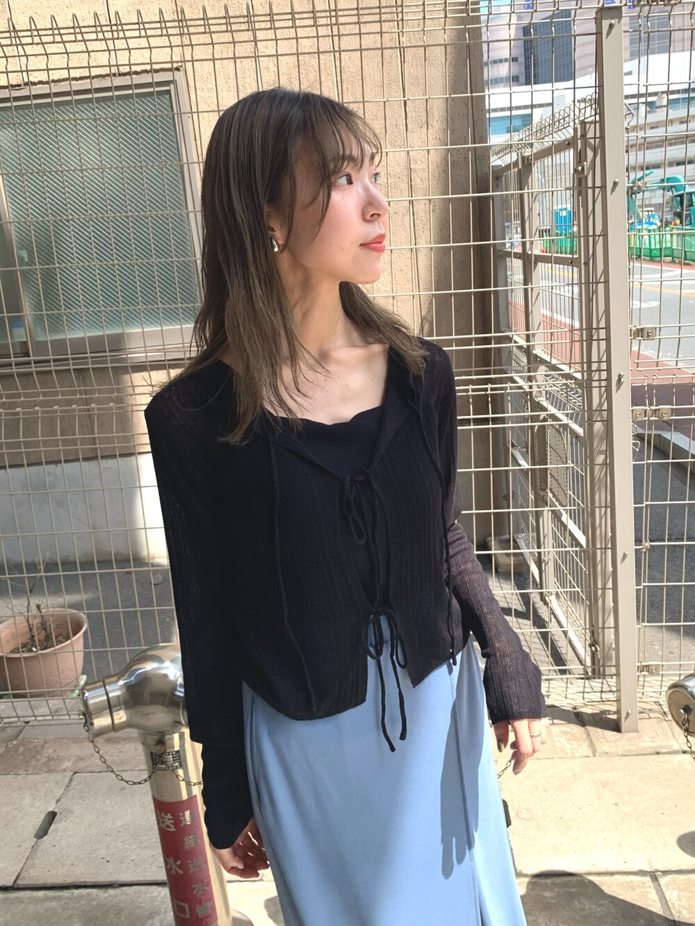 ブルー系のスカート、ブラック系のカーディガン/ボレロ、シルバー系のサンダルを着用したレディースの夏コーディネートの7枚目の写真