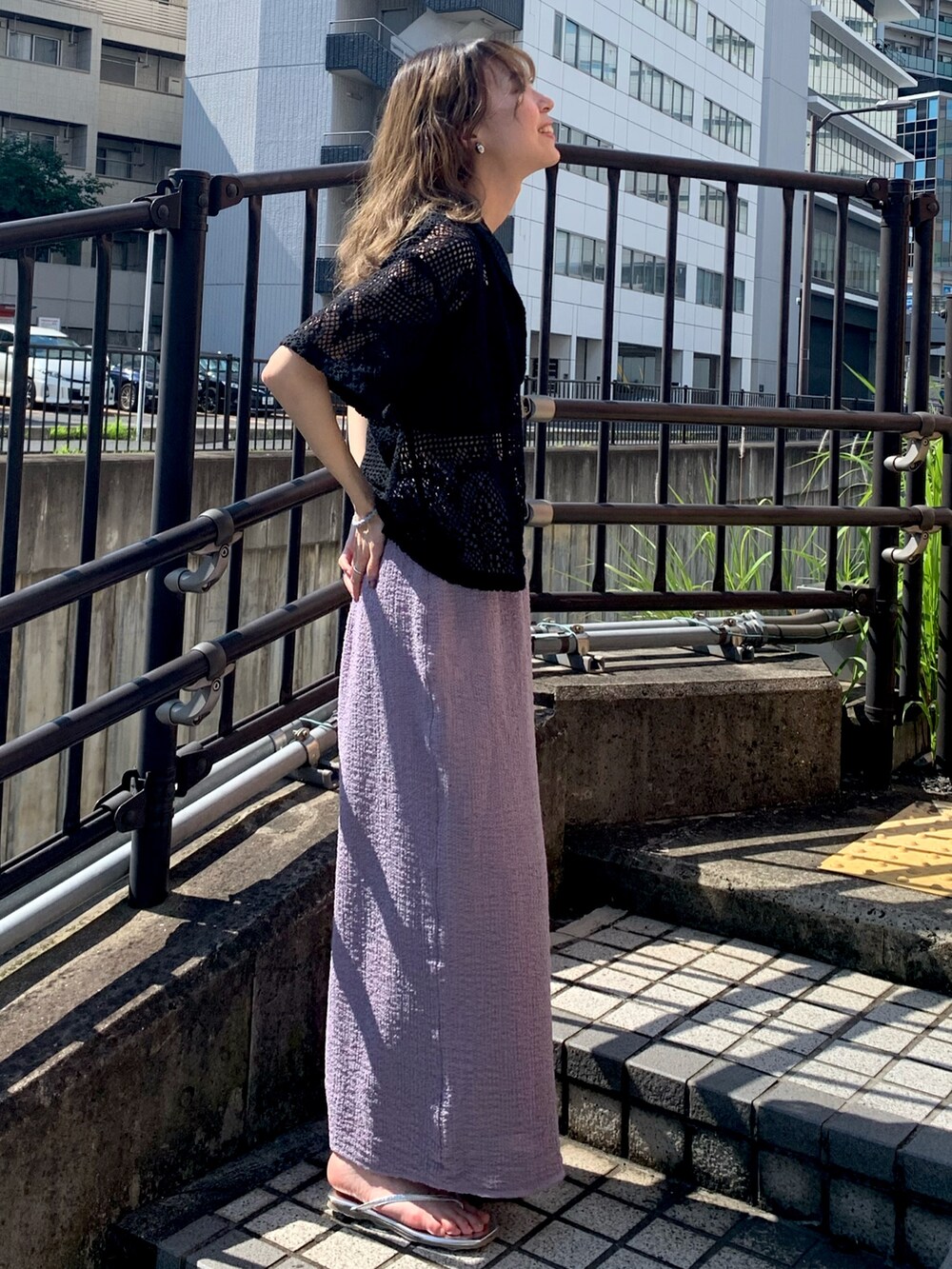 シルバー系のサンダル、パープル系のスカート、ブラック系のシャツ/ブラウスを着用したレディースの夏コーディネートの2枚目の写真