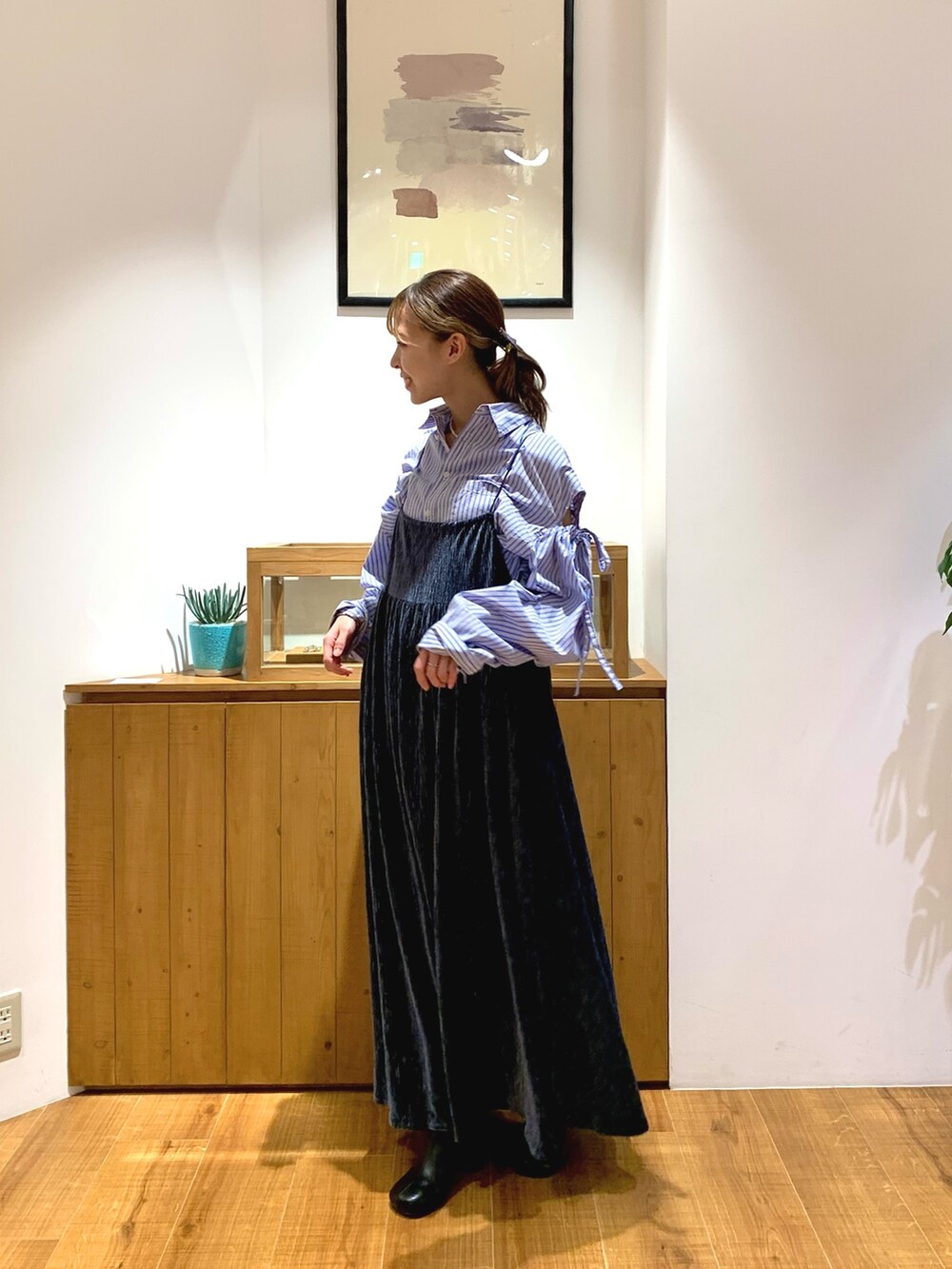 ブルー系のシャツ/ブラウス、ブルー系のワンピース、ブラック系のブーツを着用したレディースの秋コーディネートの2枚目の写真