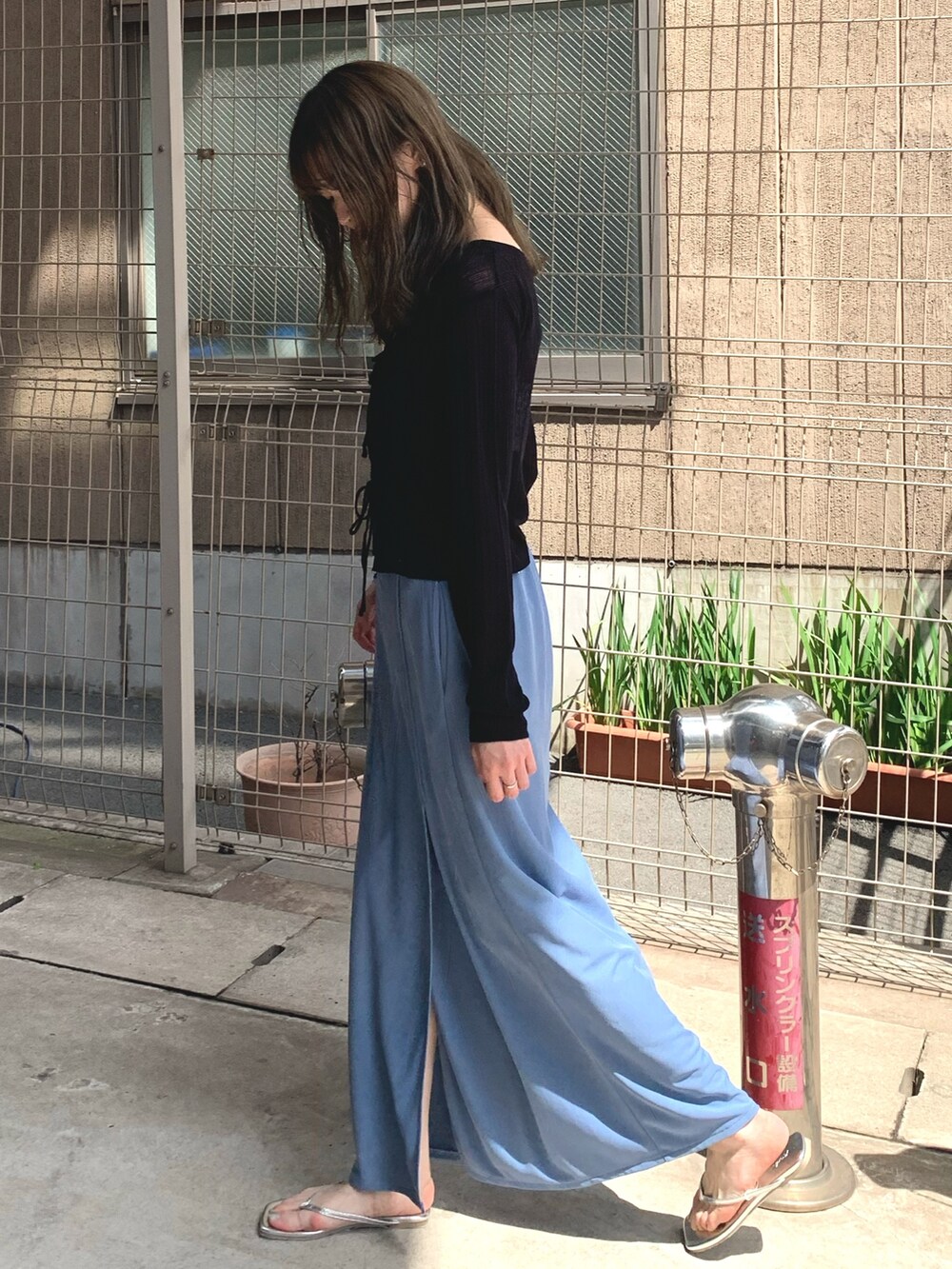 ブルー系のスカート、ブラック系のカーディガン/ボレロ、シルバー系のサンダルを着用したレディースの夏コーディネートの2枚目の写真