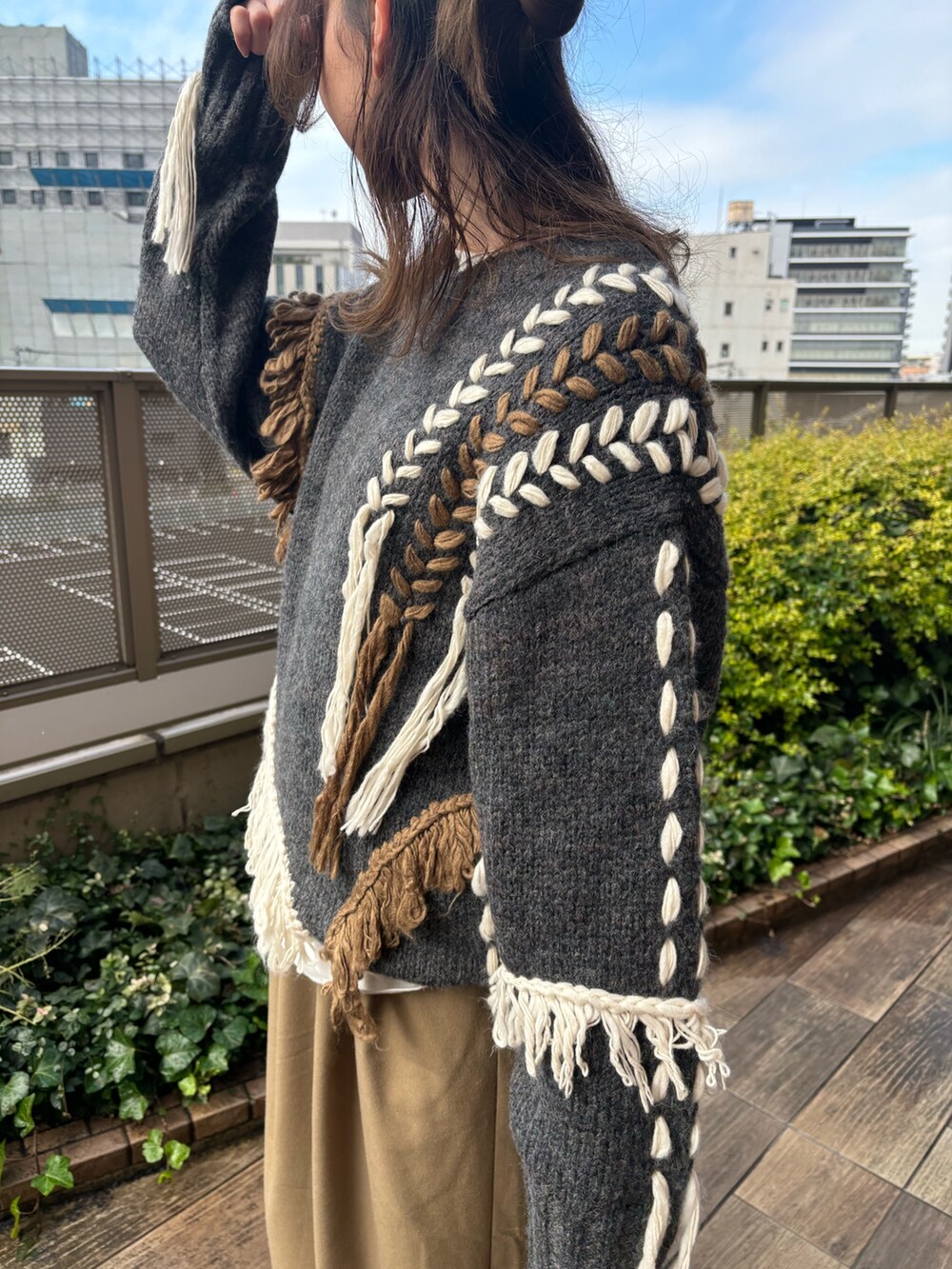 ベージュ系のその他パンツ、ホワイト系のTシャツ/カットソー、グレー系のニット/セーターを着用したレディースの冬コーディネートの5枚目の写真