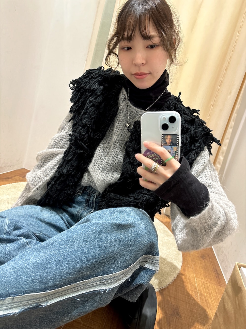 ブルー系のデニムパンツ、ブラック系のTシャツ/カットソー、ブラック系のベストを着用したレディースの秋コーディネートの6枚目の写真