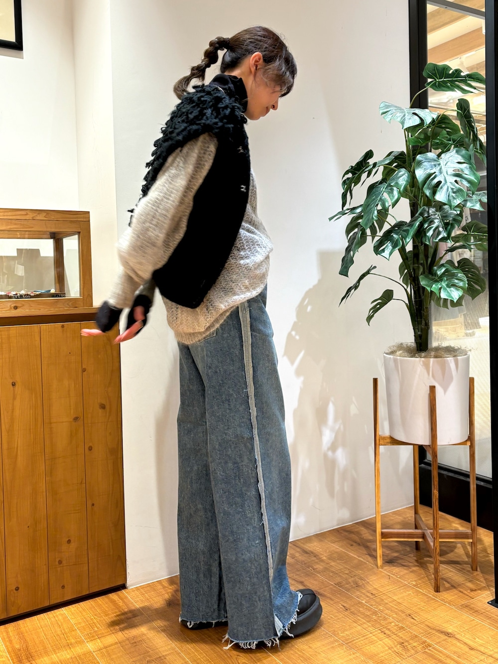 ブルー系のデニムパンツ、ブラック系のTシャツ/カットソー、ブラック系のベストを着用したレディースの秋コーディネートの2枚目の写真