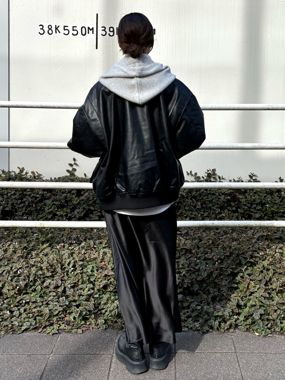 ホワイト系のTシャツ/カットソー、ブラック系のブルゾン、ブラック系のスカートを着用したレディースの冬コーディネートの3枚目の写真