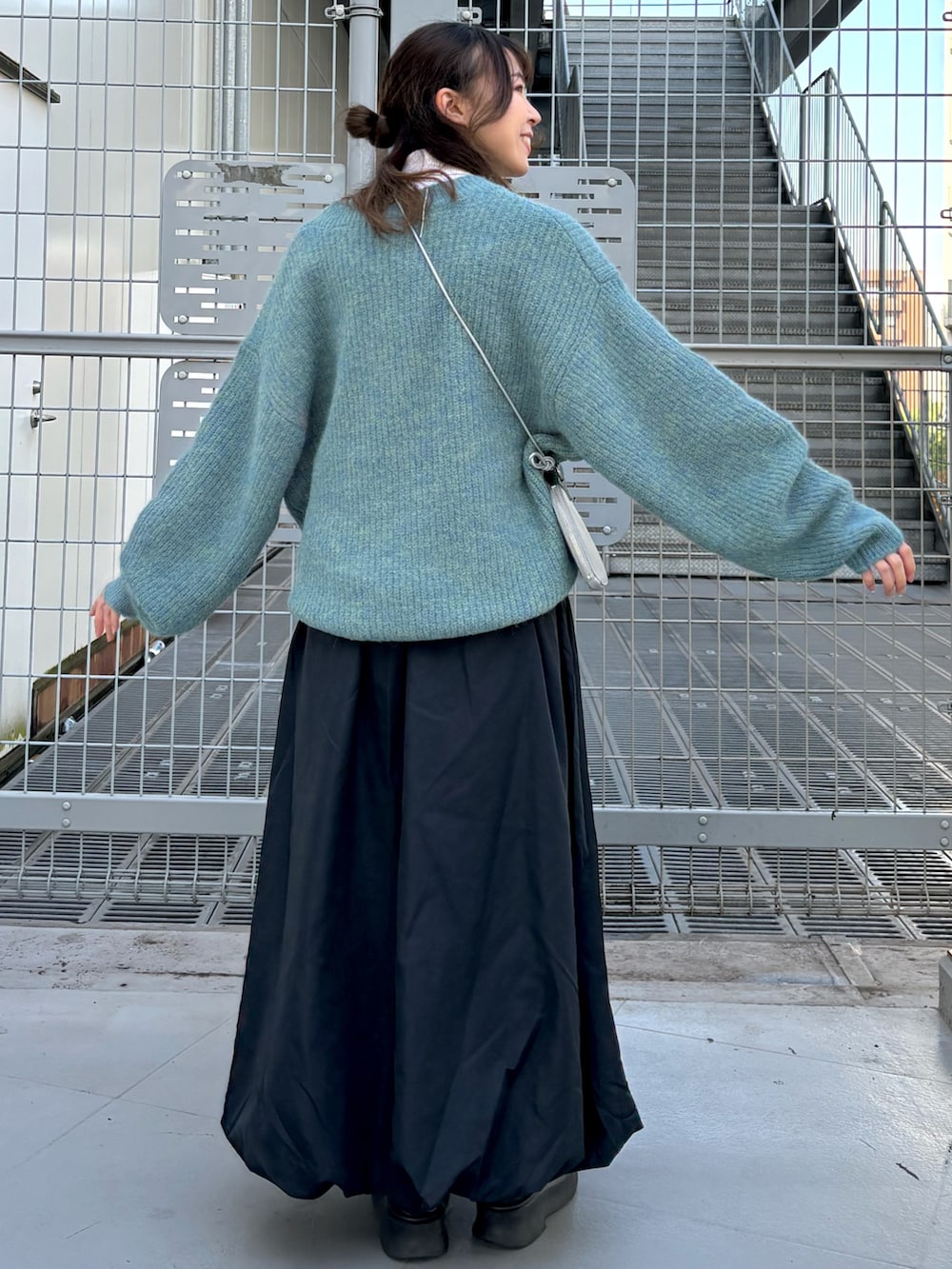 ホワイト系のニット/セーター、ブルー系のニット/セーター、シルバー系のショルダーバッグを着用したレディースの冬コーディネートの3枚目の写真