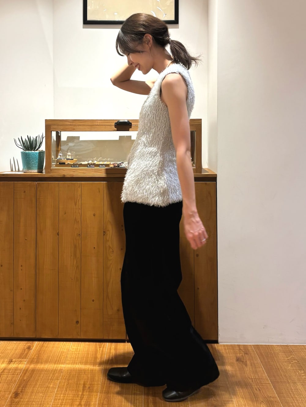 ブラック系のデニムパンツ、シルバー系のニット/セーターを着用したレディースの夏コーディネートの2枚目の写真