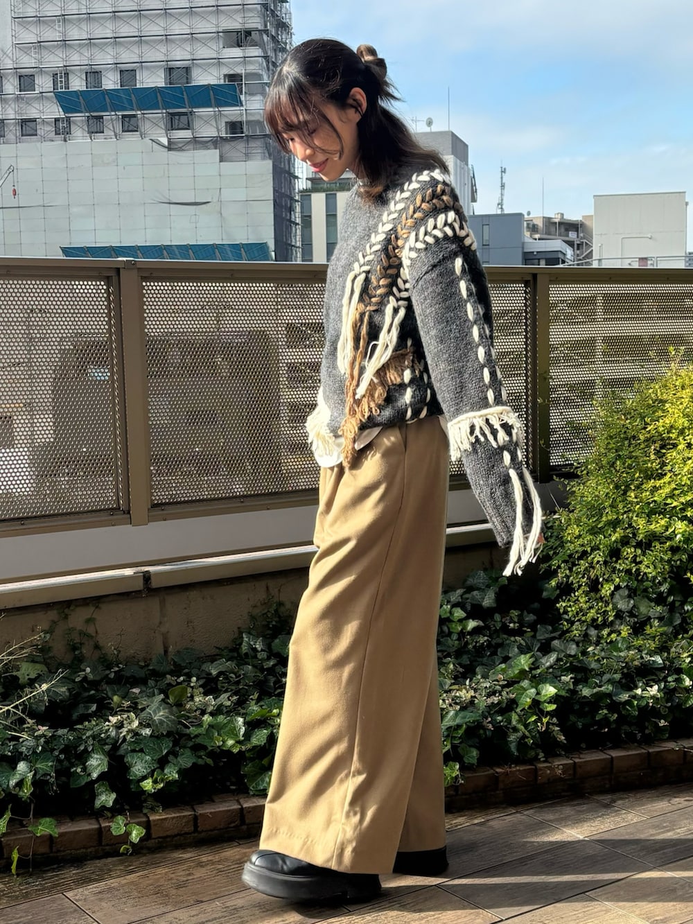 ベージュ系のその他パンツ、ホワイト系のTシャツ/カットソー、グレー系のニット/セーターを着用したレディースの冬コーディネートの2枚目の写真