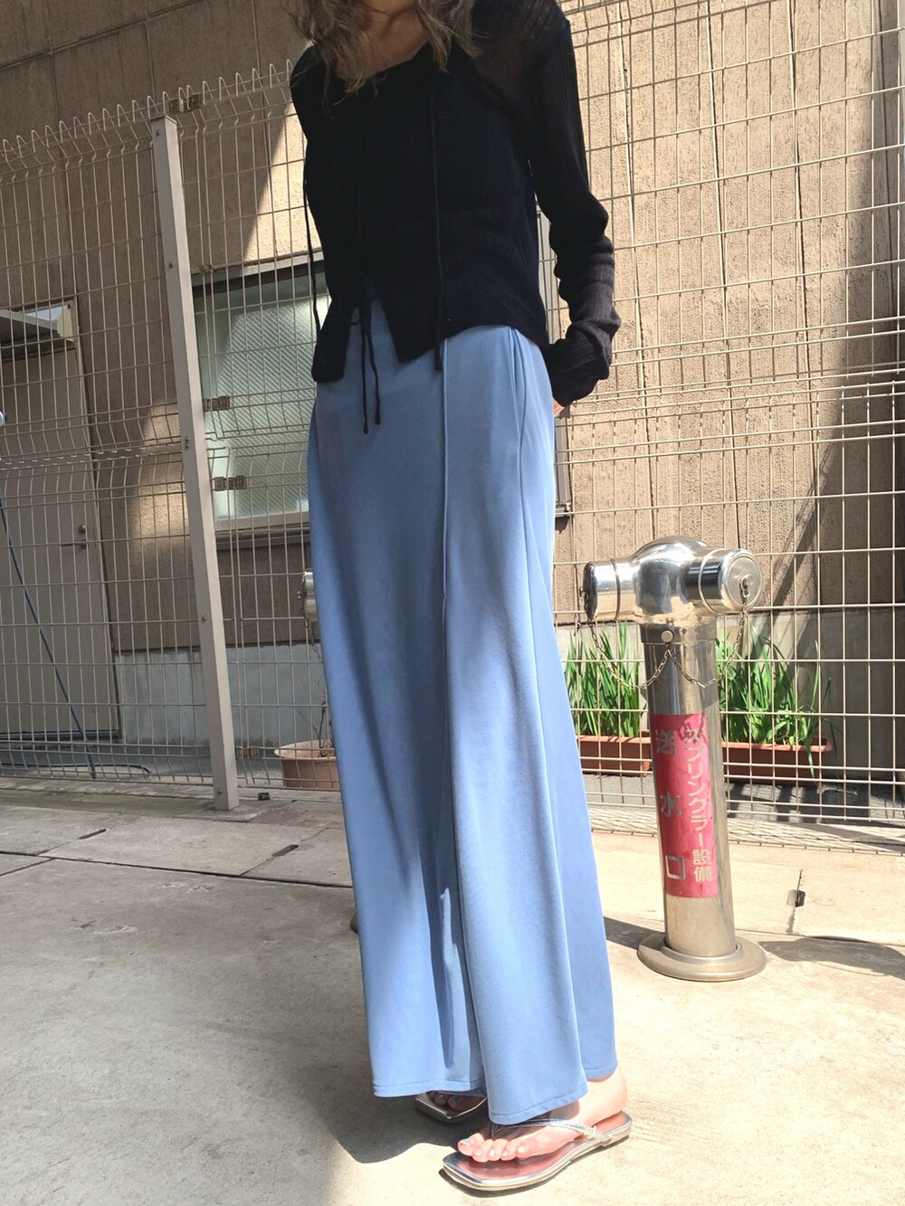 ブルー系のスカート、ブラック系のカーディガン/ボレロ、シルバー系のサンダルを着用したレディースの夏コーディネートの5枚目の写真