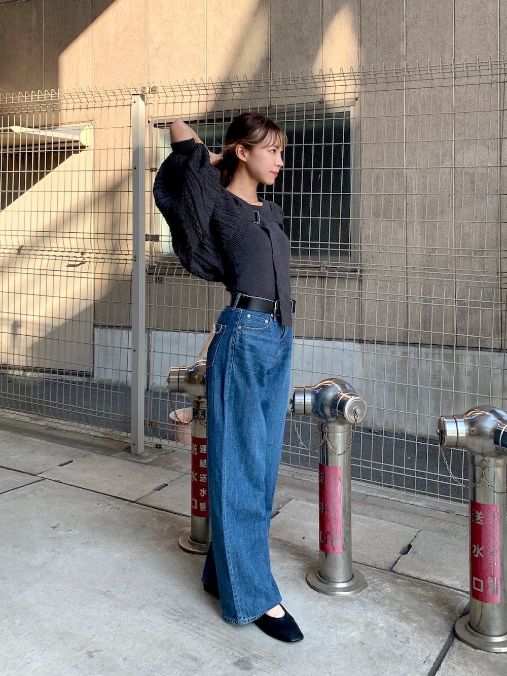 ブルー系のデニムパンツ、グレー系のカーディガン/ボレロ、ブラック系のパンプスを着用したレディースの秋コーディネートの3枚目の写真