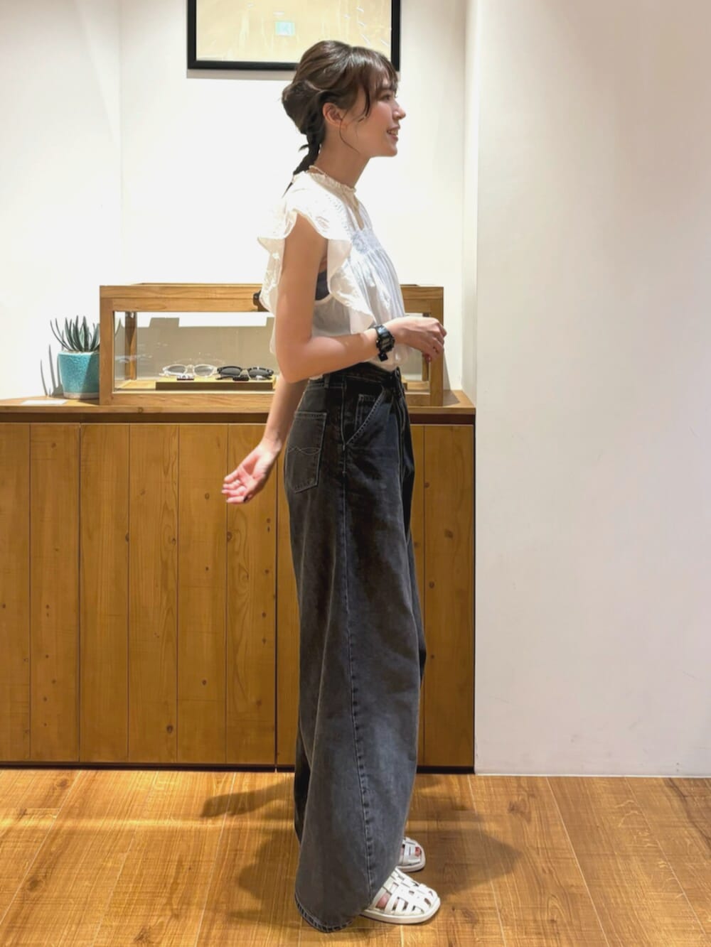 ブラック系のデニムパンツ、ホワイト系のシャツ/ブラウスを着用したレディースの夏コーディネートの2枚目の写真