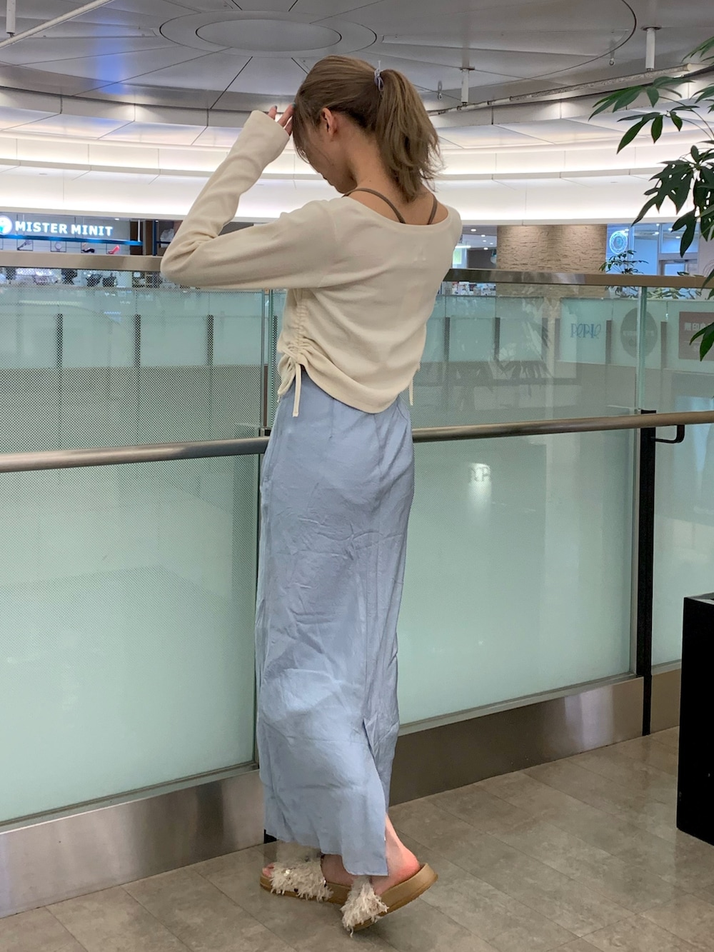 ホワイト系のサンダル、ホワイト系のTシャツ/カットソー、ブルー系のスカートを着用したレディースの春コーディネートの2枚目の写真