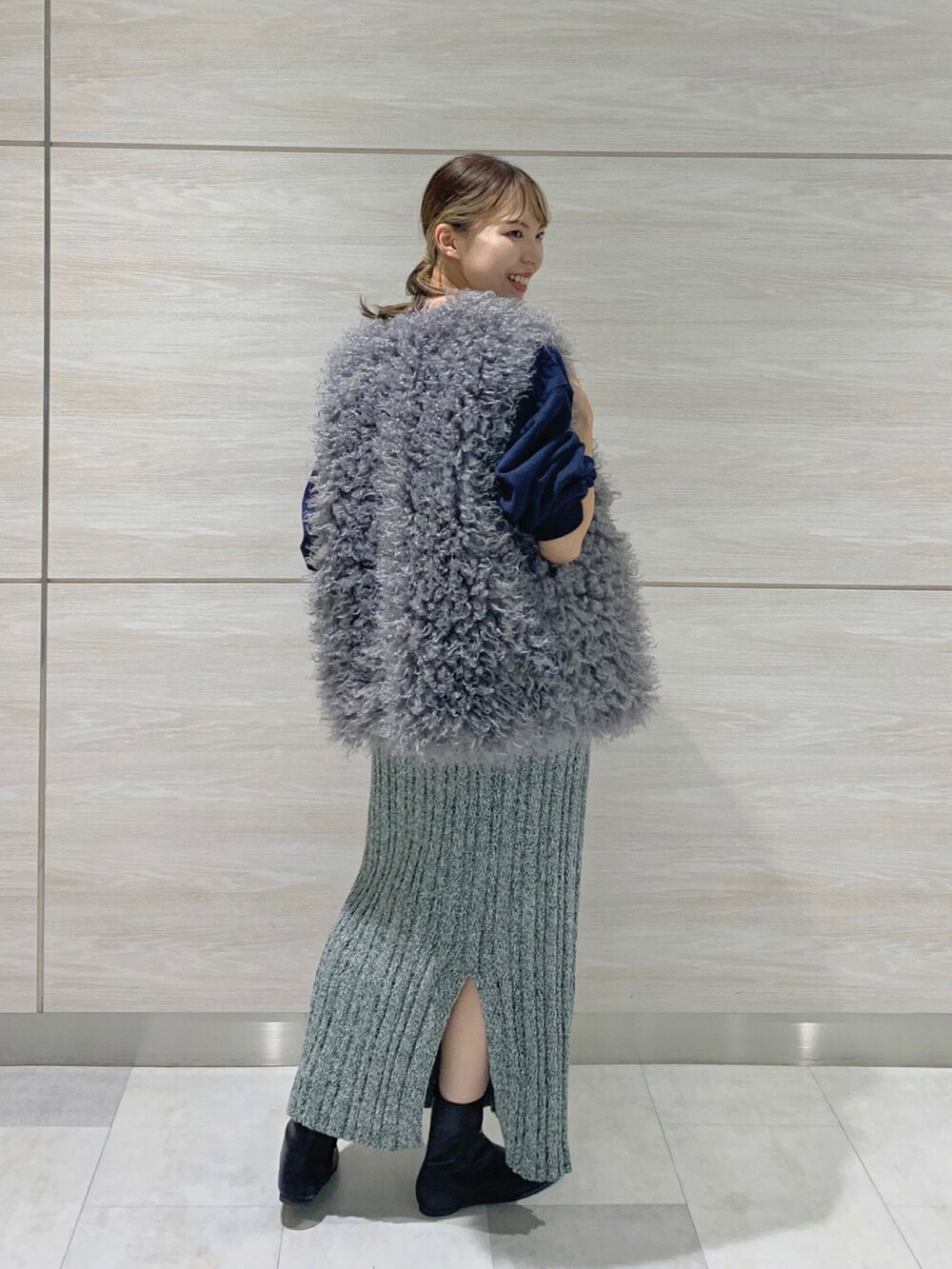 ブラック系のブーツ、グリーン系のスカート、ブルー系のスウェットを着用したレディースの秋コーディネートの2枚目の写真