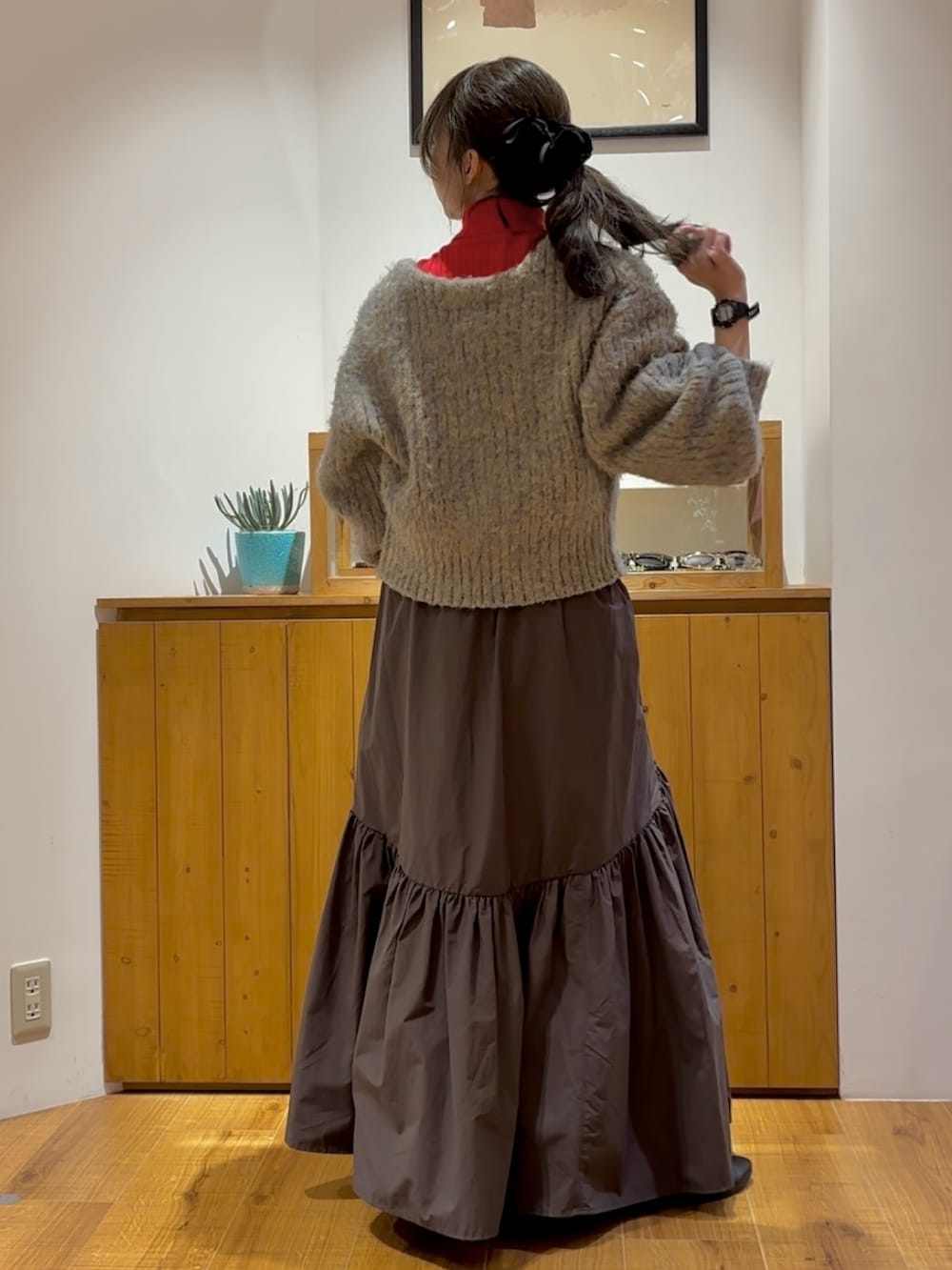 グレー系のスカート、グレー系のニット/セーター、レッド系のニット/セーターを着用したレディースの秋コーディネートの4枚目の写真