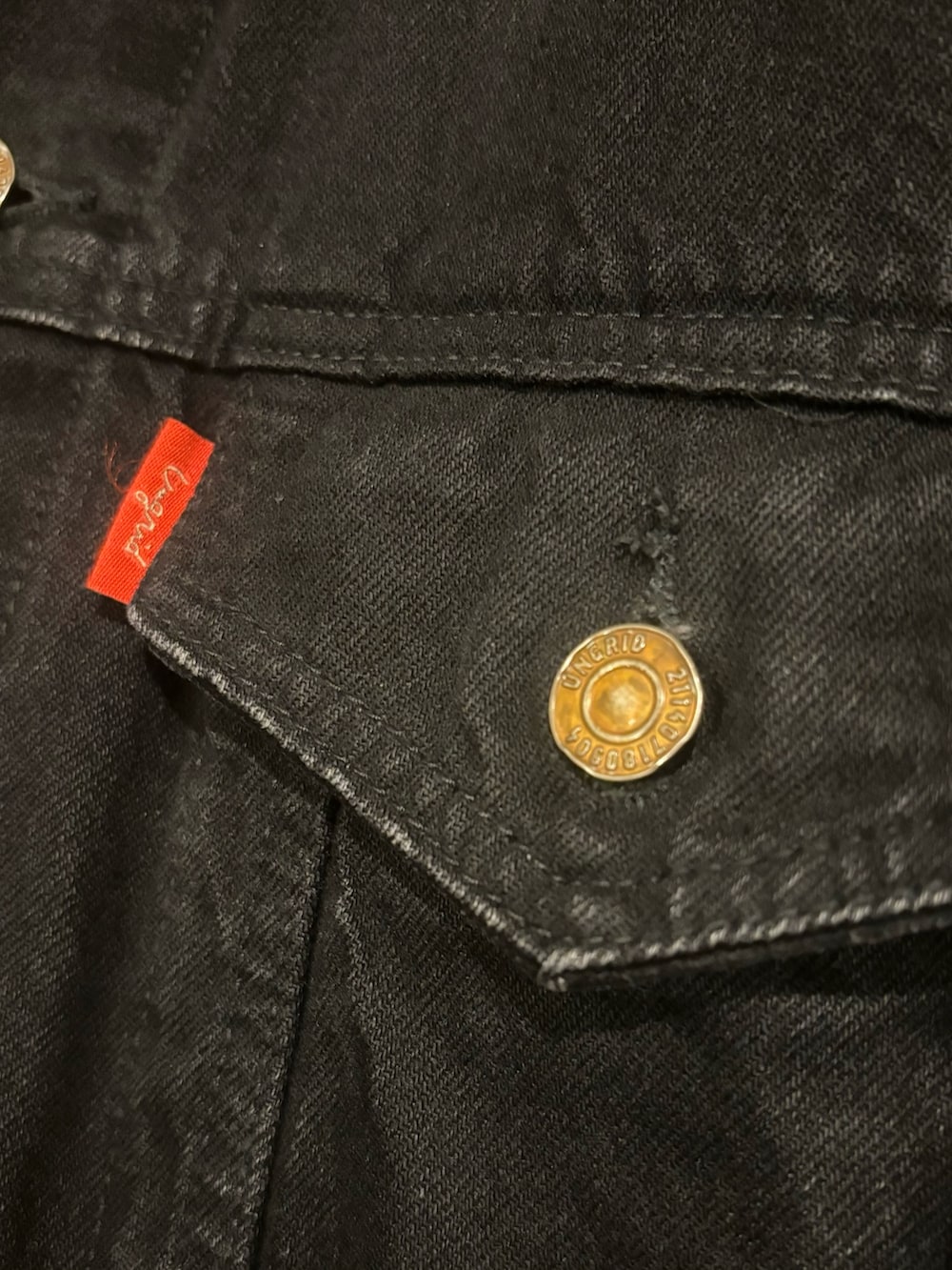 ブラック系のデニムジャケット、レッド系のニット/セーター、ブラック系のデニムパンツを着用したレディースの秋コーディネートの7枚目の写真