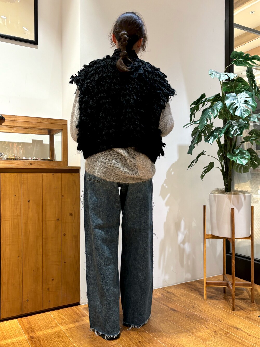 ブルー系のデニムパンツ、ブラック系のTシャツ/カットソー、ブラック系のベストを着用したレディースの秋コーディネートの3枚目の写真