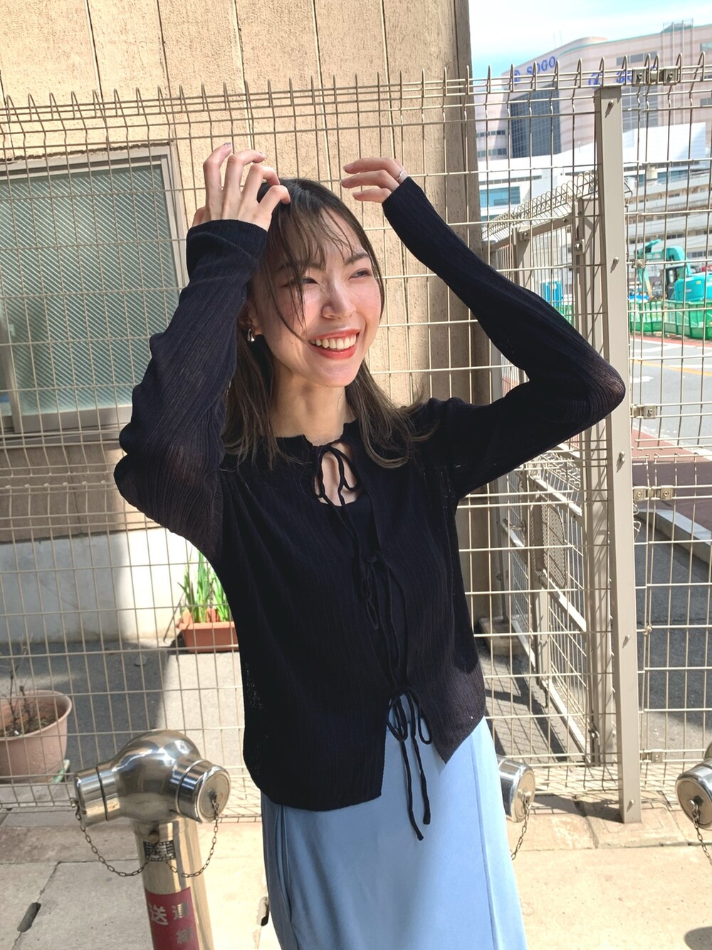 ブルー系のスカート、ブラック系のカーディガン/ボレロ、シルバー系のサンダルを着用したレディースの夏コーディネートの6枚目の写真