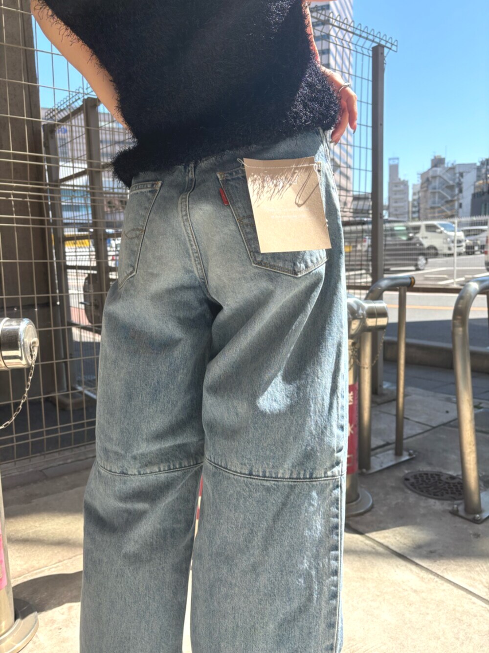 ブラック系のパンプス、ブラック系のベスト、ブルー系のデニムジャケットを着用したレディースの春コーディネートの6枚目の写真