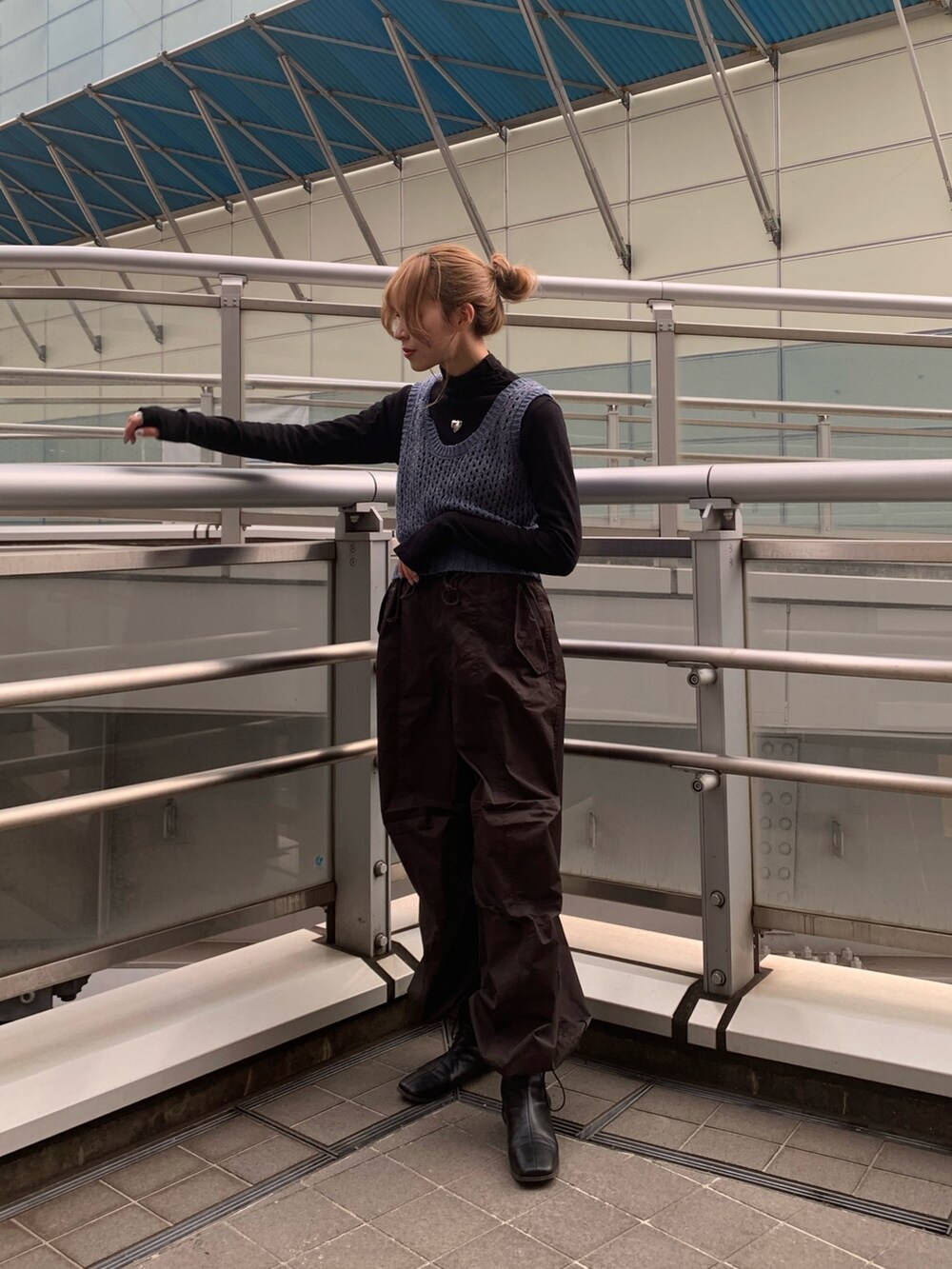 ブルー系のチェスターコート、ブラック系のブーツ、ブラック系のTシャツ/カットソーを着用したレディースの冬コーディネートの4枚目の写真