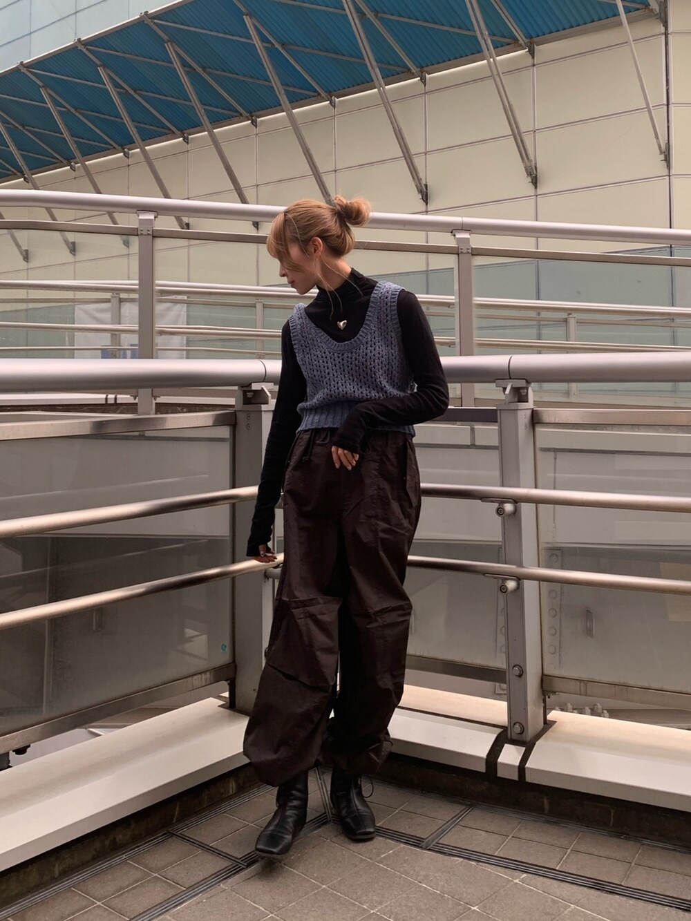 ブルー系のチェスターコート、ブラック系のブーツ、ブラック系のTシャツ/カットソーを着用したレディースの冬コーディネートの3枚目の写真