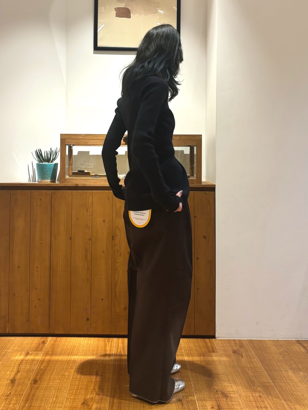 ブラウン系のその他パンツ、ブラック系のニット/セーターを着用したレディースの秋コーディネートの2枚目の写真