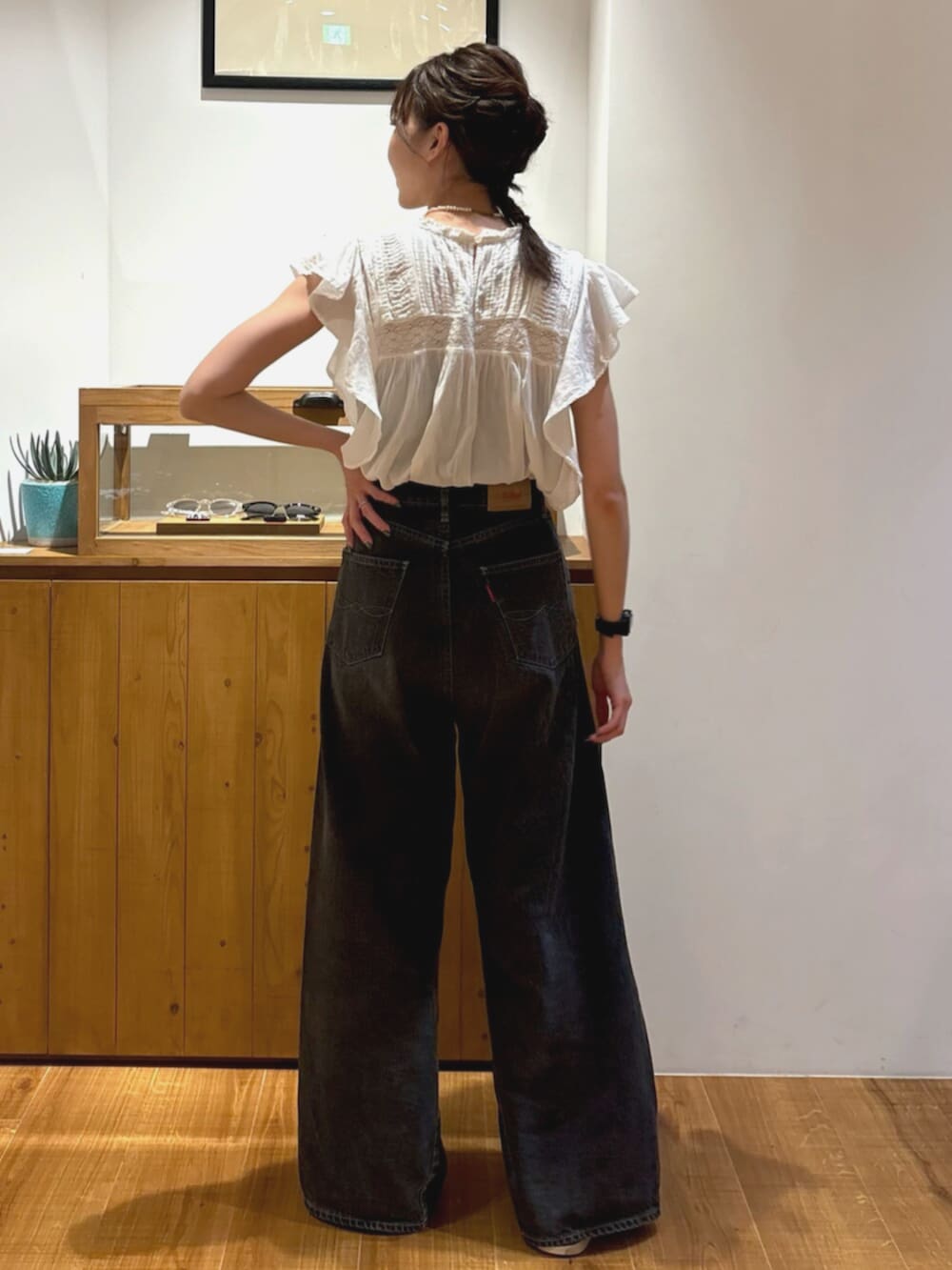 ブラック系のデニムパンツ、ホワイト系のシャツ/ブラウスを着用したレディースの夏コーディネートの3枚目の写真