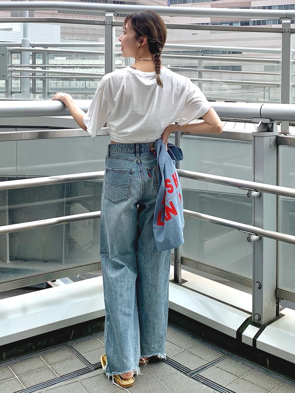 ホワイト系のTシャツ/カットソー、ブルー系のデニムパンツ、ゴールド系のローファーを着用したレディースの夏コーディネートの3枚目の写真