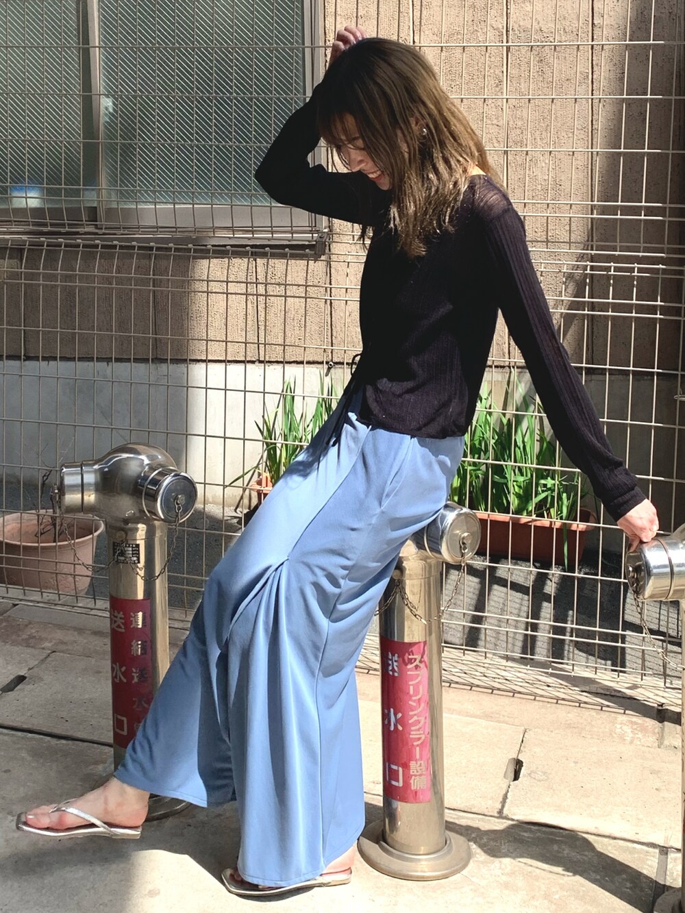ブルー系のスカート、ブラック系のカーディガン/ボレロ、シルバー系のサンダルを着用したレディースの夏コーディネートの4枚目の写真